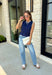Classic with a touch of charm, this navy sweater tank is made for the season ahead. The rich autumn hue is beautifully accented with crisp white trim and a delicate scalloped hem, creating a timeless look that's both polished and playful. Crafted from a soft sweater knit, it's perfect for layering under your favorite blazer, denim jacket, or cardigan as the temperatures begin to cool. 