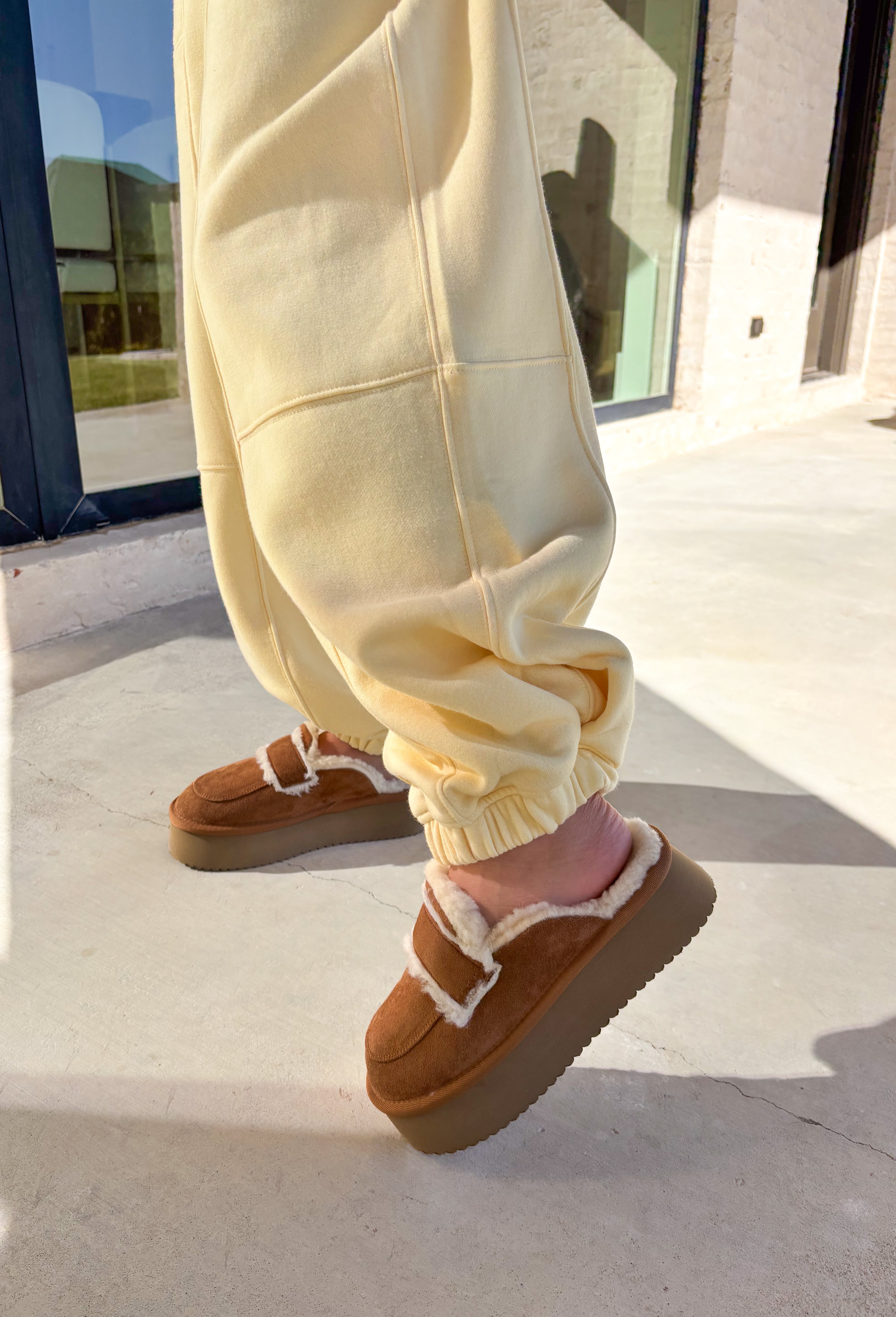 Stay cozy in style with these butter yellow barrel joggers by Rae Mode. Lined in soft fleece and finished with a drawstring elastic waistband, these joggers offer the perfect blend of comfort and warmth for chilly winter days. Featuring side and back pockets for everyday convenience, their relaxed barrel silhouette makes them ideal for lounging or layering on the go. Pair them with the matching quarter-zip pullover for a complete cozy set or wear them solo for a laid-back, stylish look.