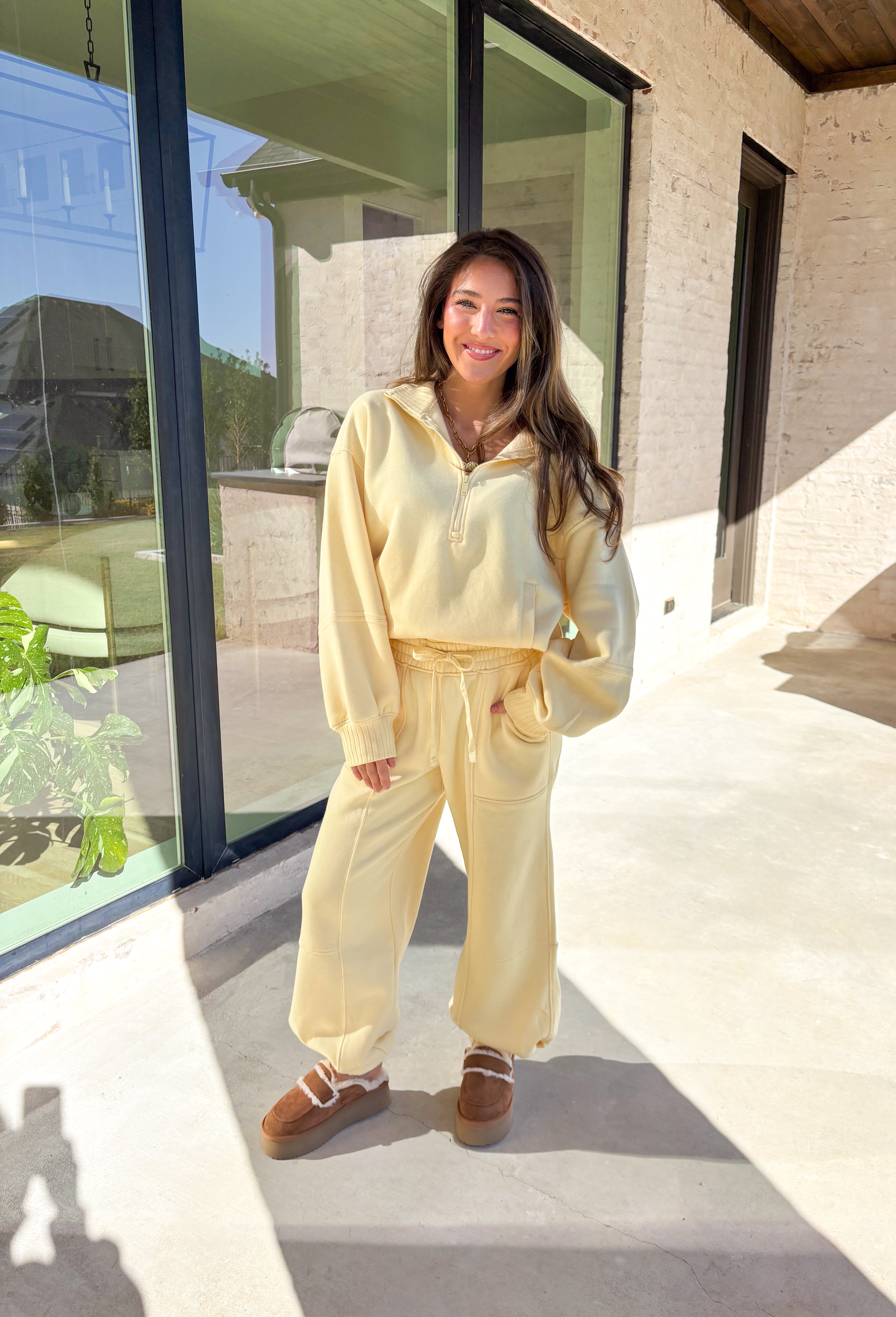 Cozy up this winter in the butter yellow fleece quarter zip pullover by Rae Mode. Designed with ribbed detailing along the collar, hem, and sleeve cuffs, this pullover combines a relaxed fit with an effortlessly polished look. The soft fleece interior and front pockets add extra warmth and comfort, making it the perfect throw-on for chilly days. Pair it with the matching joggers for the full set, or style it solo for an easy, laid-back outfit.