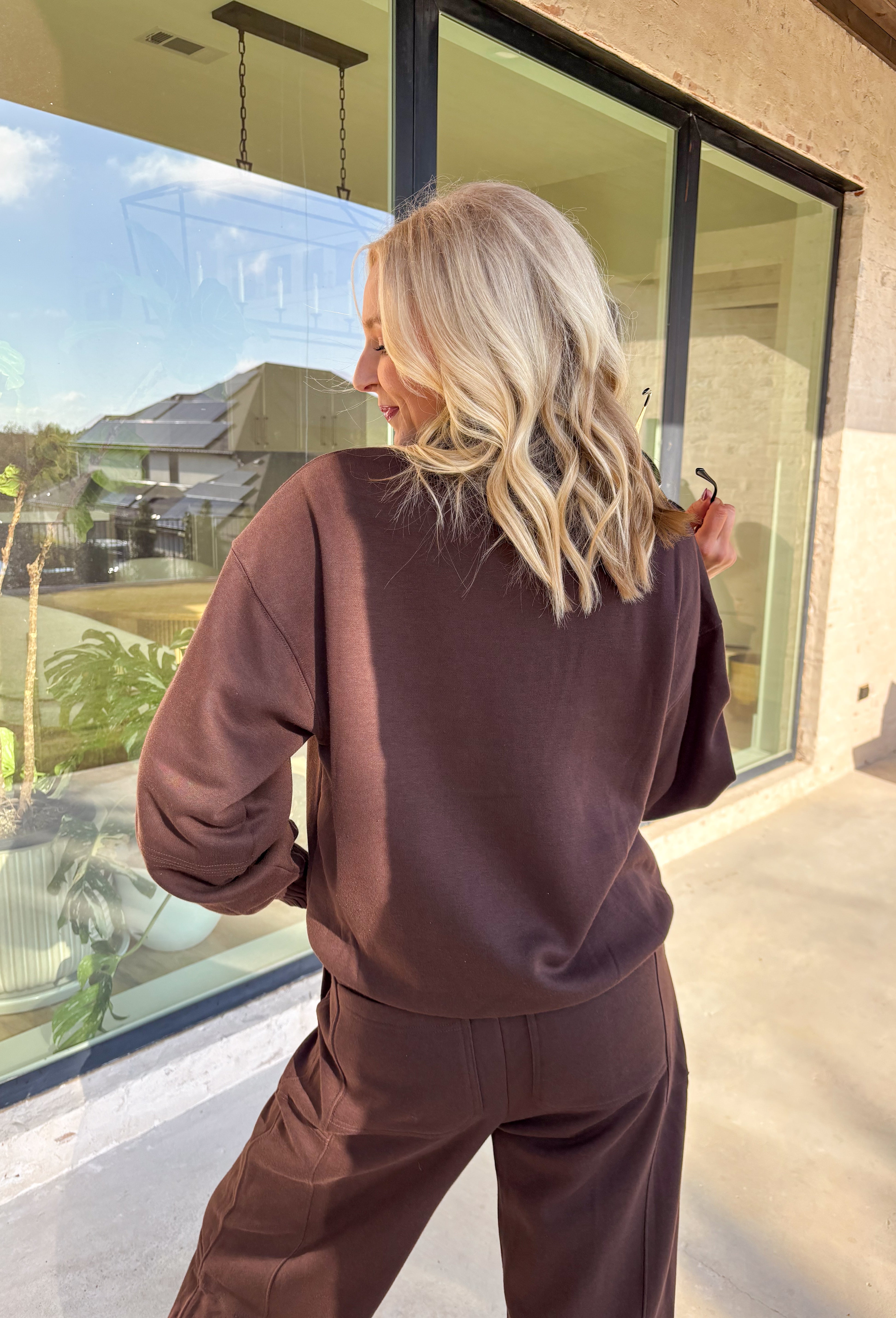 Cozy up this winter in the chocolate brown fleece quarter zip pullover by Rae Mode. Designed with ribbed detailing along the collar, hem, and sleeve cuffs, this pullover combines a relaxed fit with an effortlessly polished look. The soft fleece interior and front pockets add extra warmth and comfort, making it the perfect throw-on for chilly days. Pair it with the matching joggers for the full set, or style it solo for an easy, laid-back outfit.