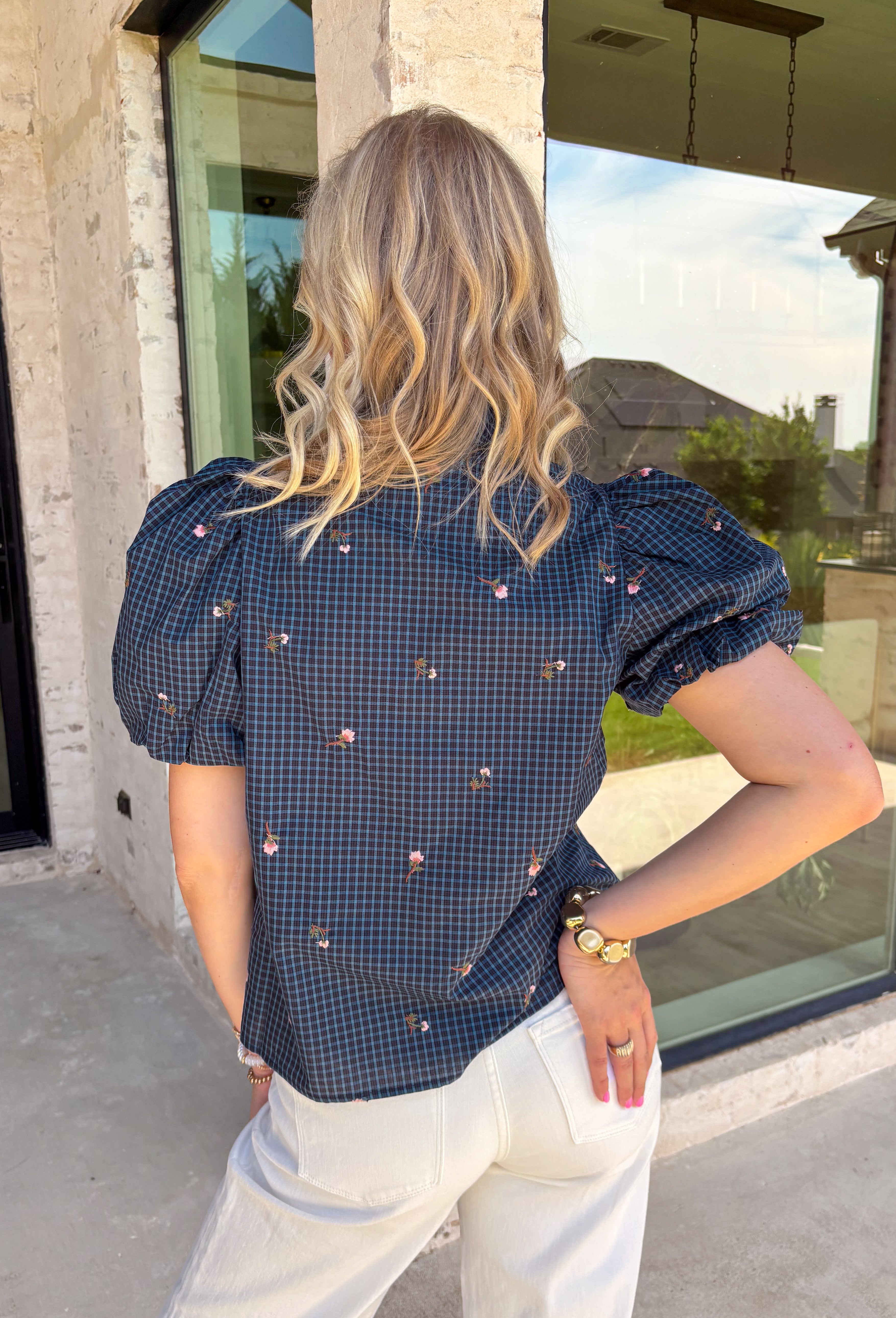 Classic fall patterns and delicate embroidery come together beautifully in this charming top. Featuring a navy and blue checkered print accented with light pink floral embroidery, this top brings a fresh, feminine touch to your autumn wardrobe. The self-tie neckline adds timeless charm, while the short puff sleeves with elastic cuffs create a flattering silhouette that's easy to wear from day to night. 