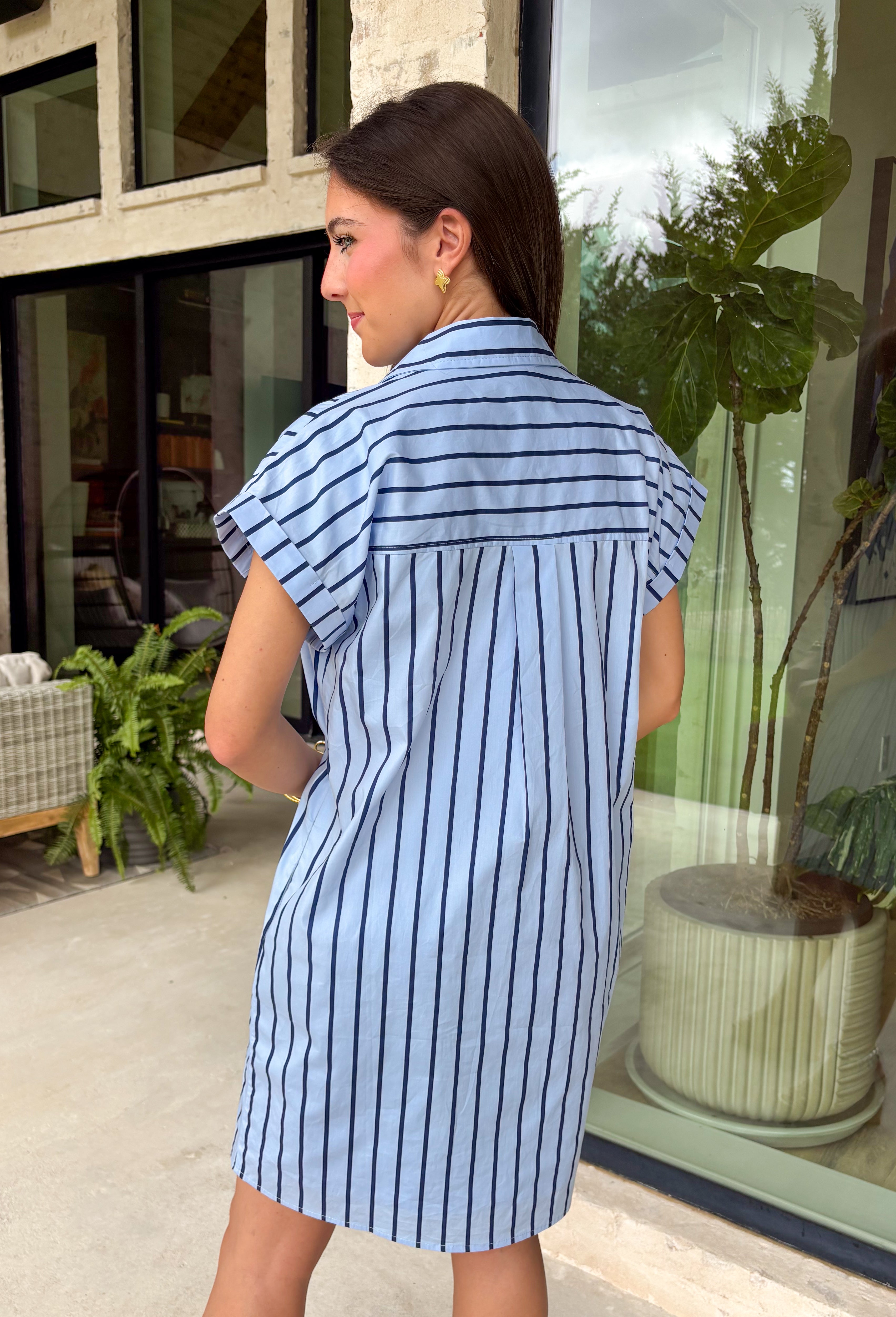 This light blue stripe dress is the kind of easy, polished piece you’ll reach for all summer long! The navy stripe print keeps it classic, while the collared v-neckline adds a slightly elevated touch that still feels effortless. With cuffed sleeves and a front pocket, it has that relaxed, everyday feel—plus side pockets (always a win). Made from breathable cotton and fully lined, it’s comfortable enough for all-day wear. From errands to lunch plans, this dress makes getting ready simple. 