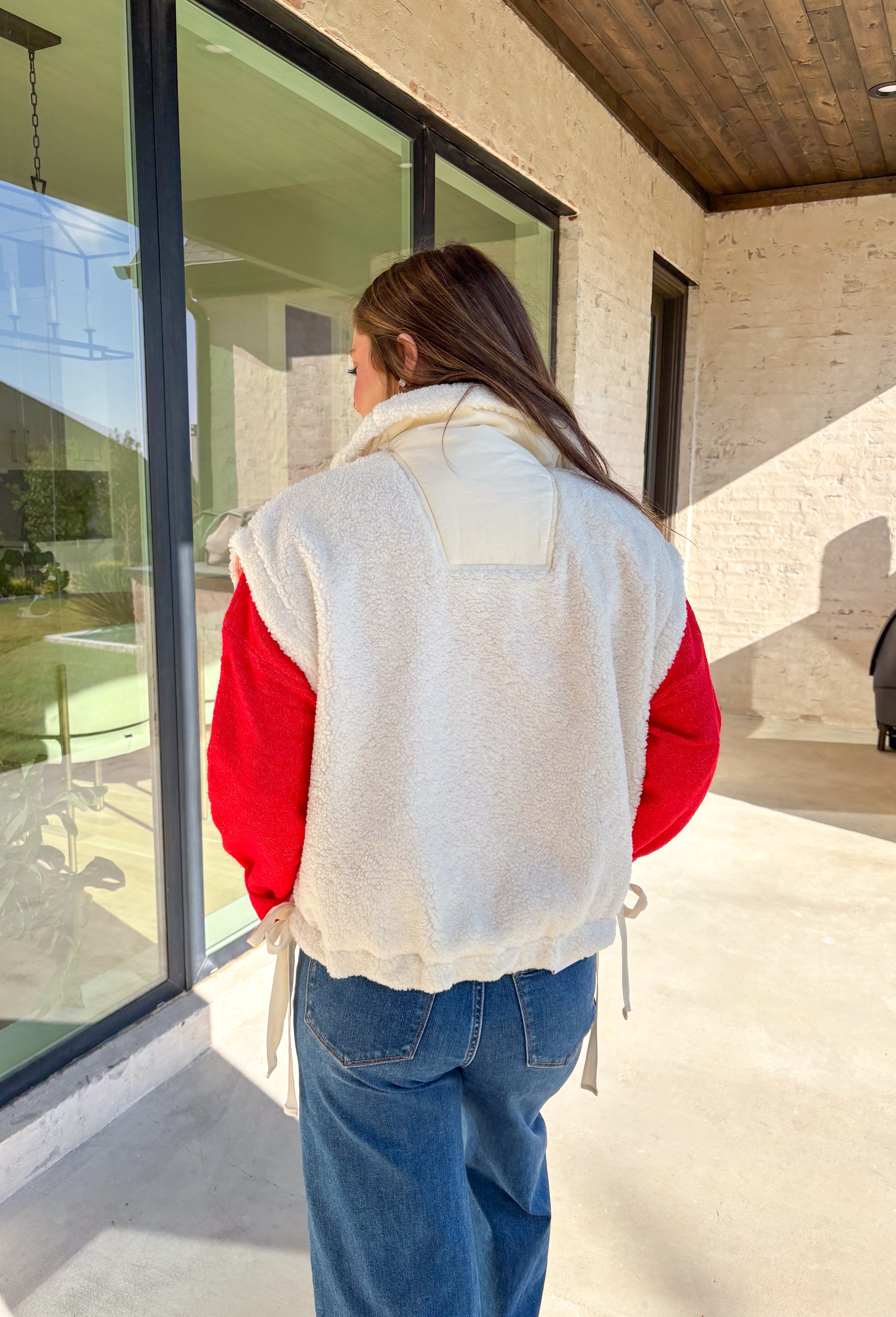 Layer on the warmth with this off white sherpa vest, the perfect cozy piece for winter. Designed with a button-down front and ivory trim, it’s accented with side pockets for practicality and tie details on the sides for an adjustable fit. The plush sherpa texture makes it a must-have layering piece, whether you’re throwing it over a chunky sweater or styling it with a casual flannel. This vest blends comfort and style for the season’s coldest days.