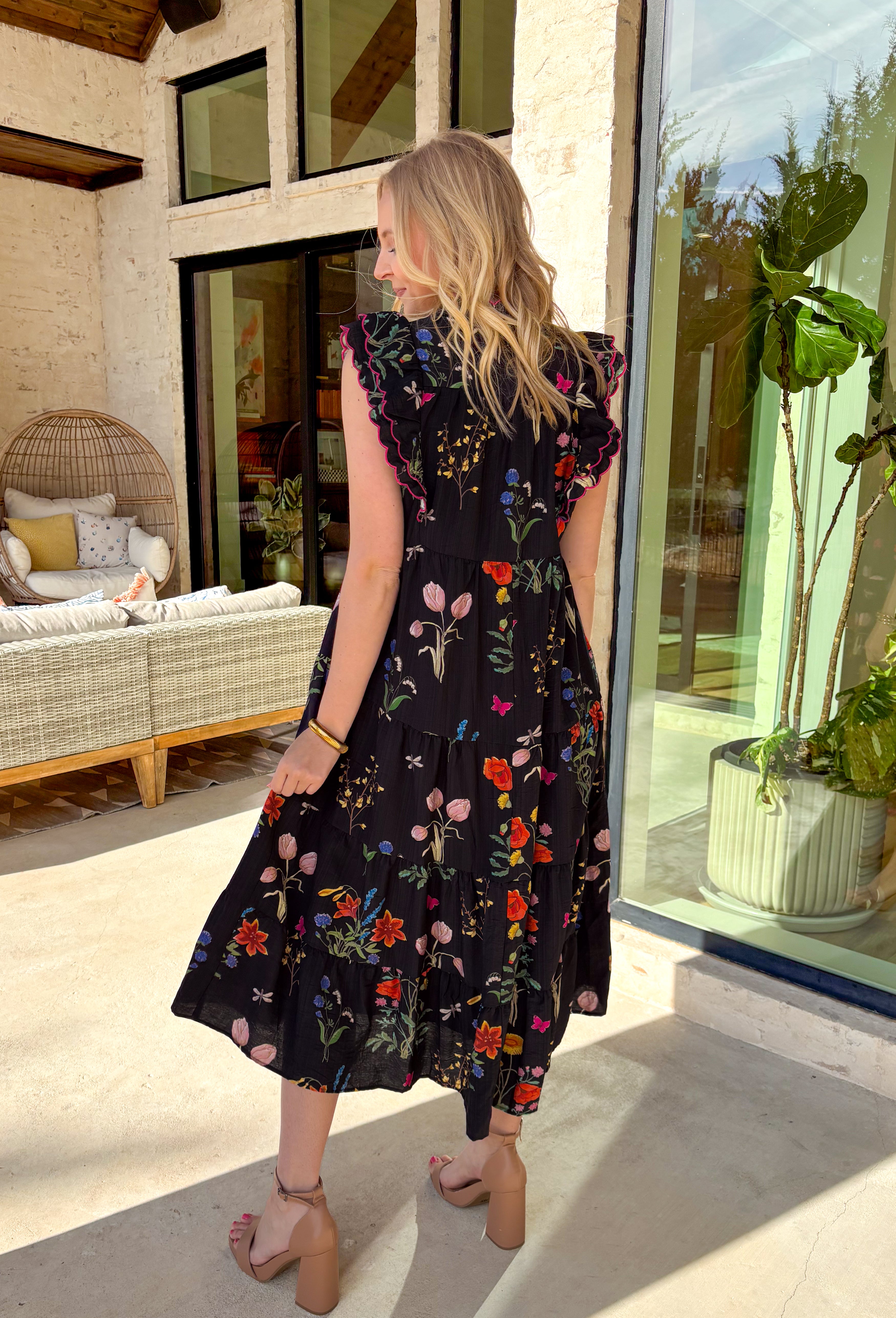 This black floral midi dress is basically a spring celebration you can wear! The colorful allover print pops beautifully against the black background, while the pink scalloped neckline and sleeves add the cutest little feminine touch. With a tiered skirt that moves like a dream and handy side pockets (because we love a practical moment), this one is made for everything from brunch dates to baby showers to twirling through the farmer’s market. You will find yourself reaching for this dress all season long!