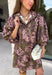 Bring effortless charm to your fall wardrobe with this beautifully detailed dress from Entro. Designed in a rich olive hue with a delicate floral print in shades of light pink and black, this timeless dress is perfect for everything from brunch dates to weekend outings. The stand neckline and partial button-front closure create a polished silhouette, while the ¾ puff sleeves are finished with sweet tie cuffs for an extra feminine touch. 