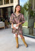 Bring effortless charm to your fall wardrobe with this beautifully detailed dress from Entro. Designed in a rich olive hue with a delicate floral print in shades of light pink and black, this timeless dress is perfect for everything from brunch dates to weekend outings. The stand neckline and partial button-front closure create a polished silhouette, while the ¾ puff sleeves are finished with sweet tie cuffs for an extra feminine touch. 