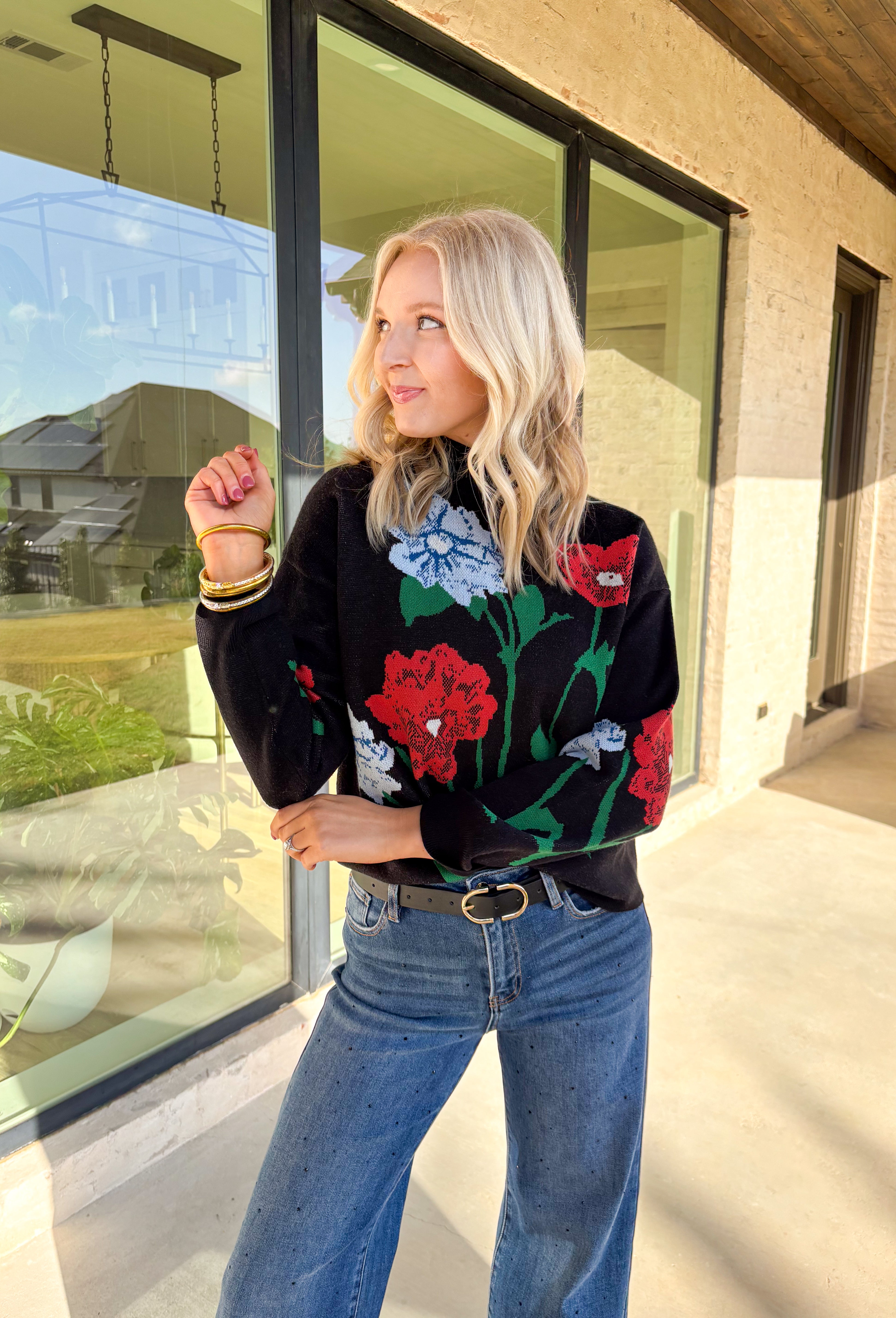 Add a touch of bold beauty to your winter wardrobe with this black mock neck sweater by Entro. Featuring a large-scale floral print in red, blue, green, tan, and off-white, this cozy knit makes a striking statement while keeping you warm. The mock neckline and soft stretch fabric make it perfect for chilly days—easy to dress up or wear casually through the season.