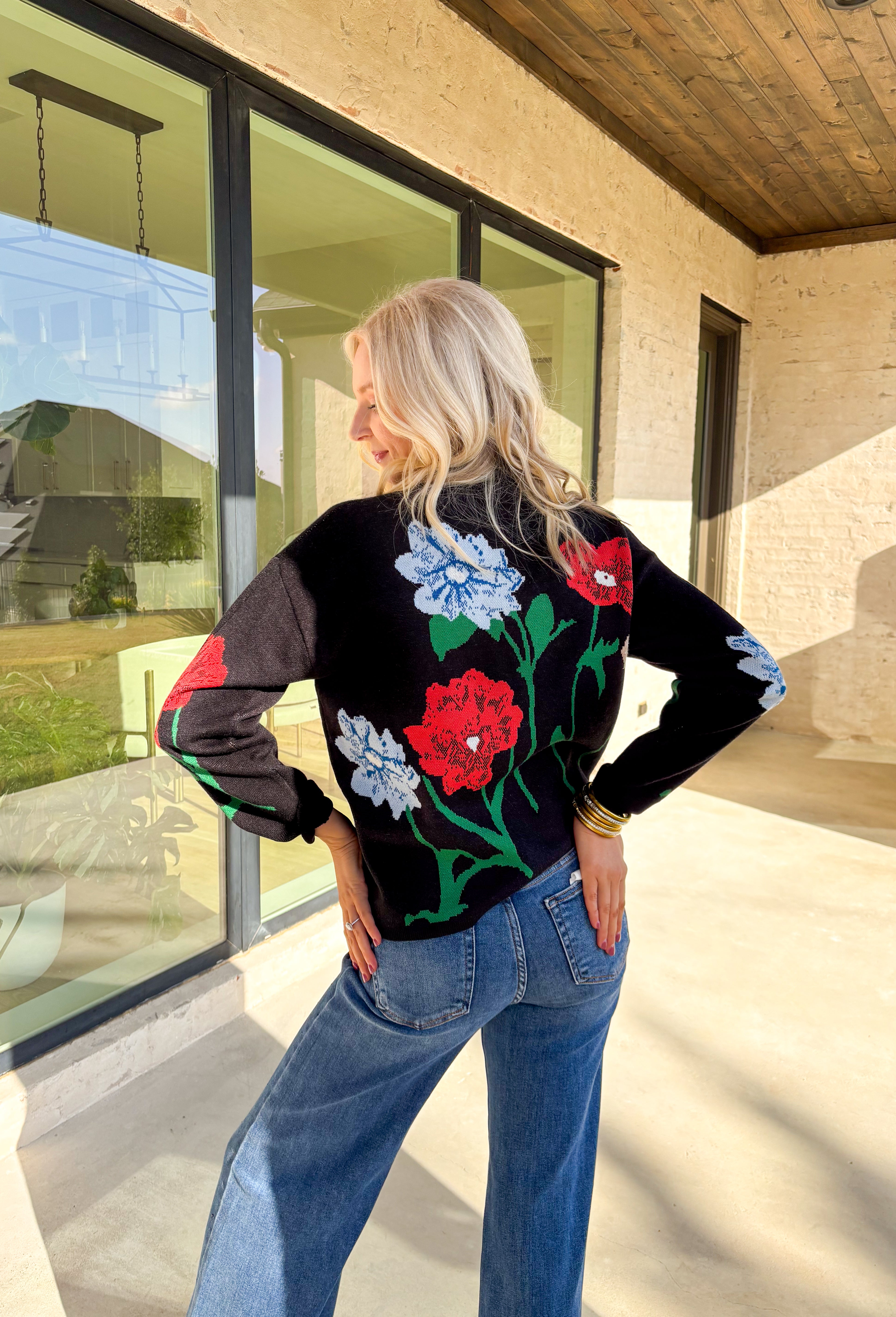 Add a touch of bold beauty to your winter wardrobe with this black mock neck sweater by Entro. Featuring a large-scale floral print in red, blue, green, tan, and off-white, this cozy knit makes a striking statement while keeping you warm. The mock neckline and soft stretch fabric make it perfect for chilly days—easy to dress up or wear casually through the season.