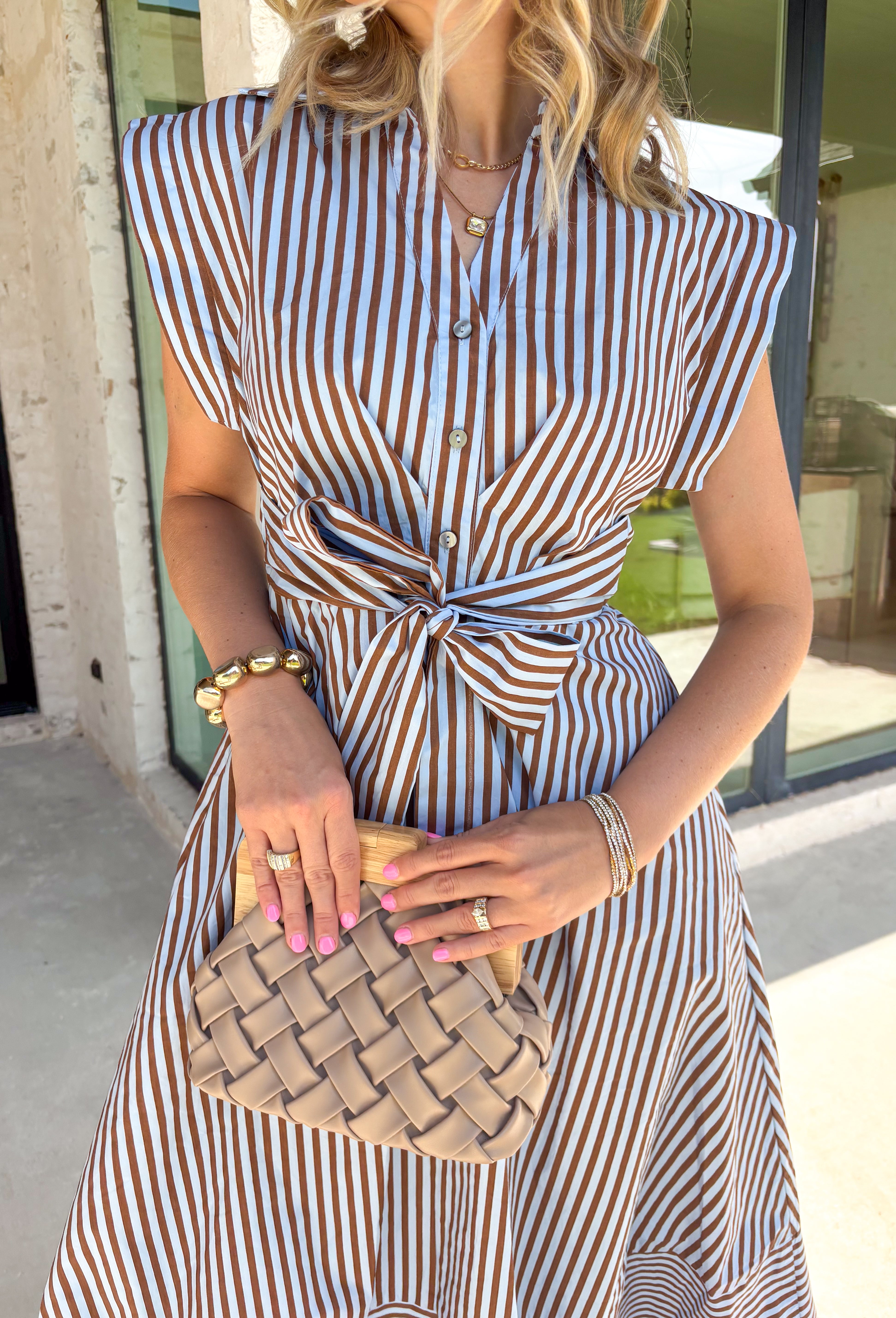 Rich autumn hues and timeless details make this striped midi dress an easy favorite for the season ahead. Featuring light blue and brown stripes, this dress captures everything we love about fall. The flattering v-neckline is finished with a sweet self-tie detail, while the gathered waist creates a feminine silhouette that's both comfortable and flattering. Cap sleeves, side pockets, and a fully lined design make it as practical as it is stylish. 
