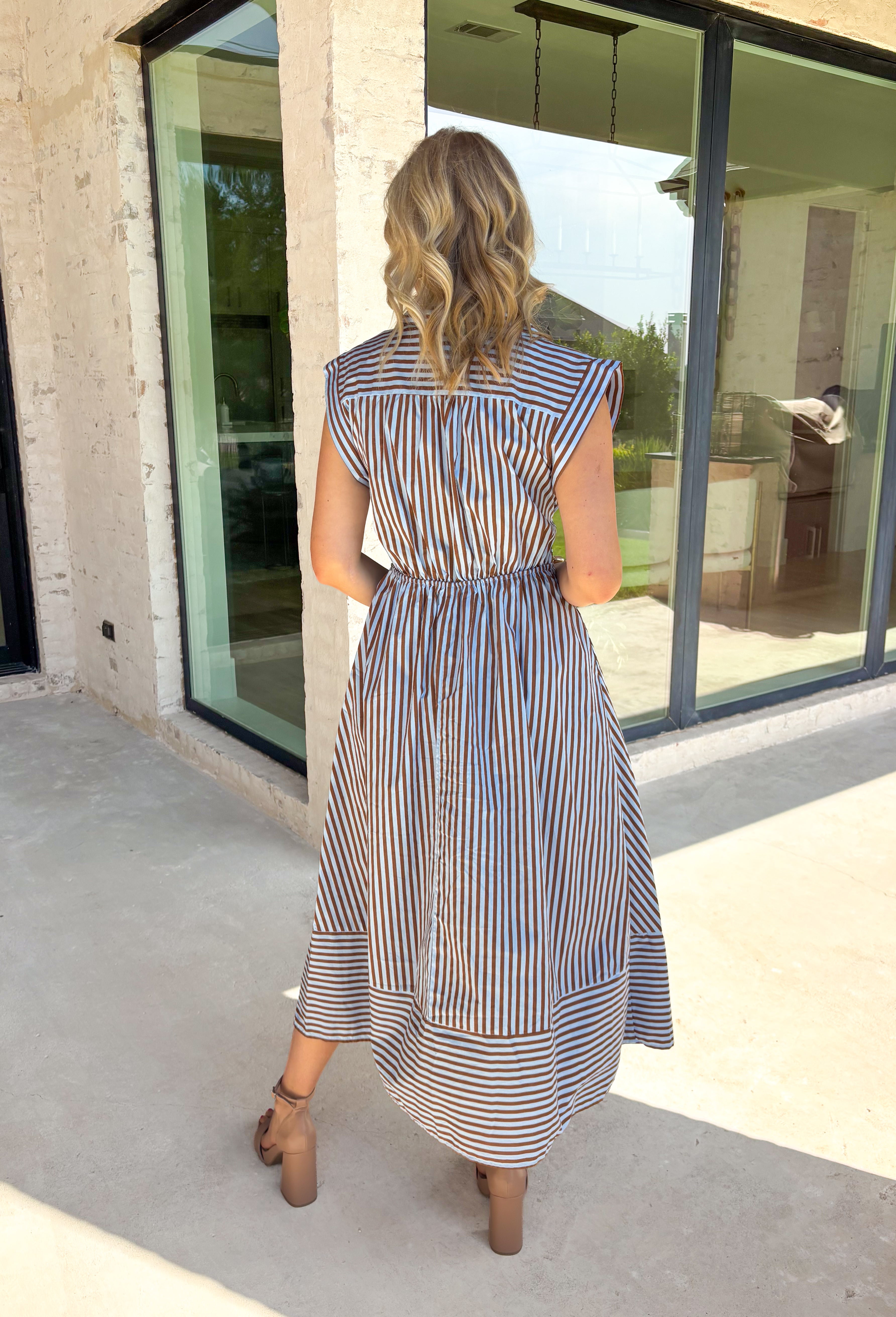 Rich autumn hues and timeless details make this striped midi dress an easy favorite for the season ahead. Featuring light blue and brown stripes, this dress captures everything we love about fall. The flattering v-neckline is finished with a sweet self-tie detail, while the gathered waist creates a feminine silhouette that's both comfortable and flattering. Cap sleeves, side pockets, and a fully lined design make it as practical as it is stylish. 