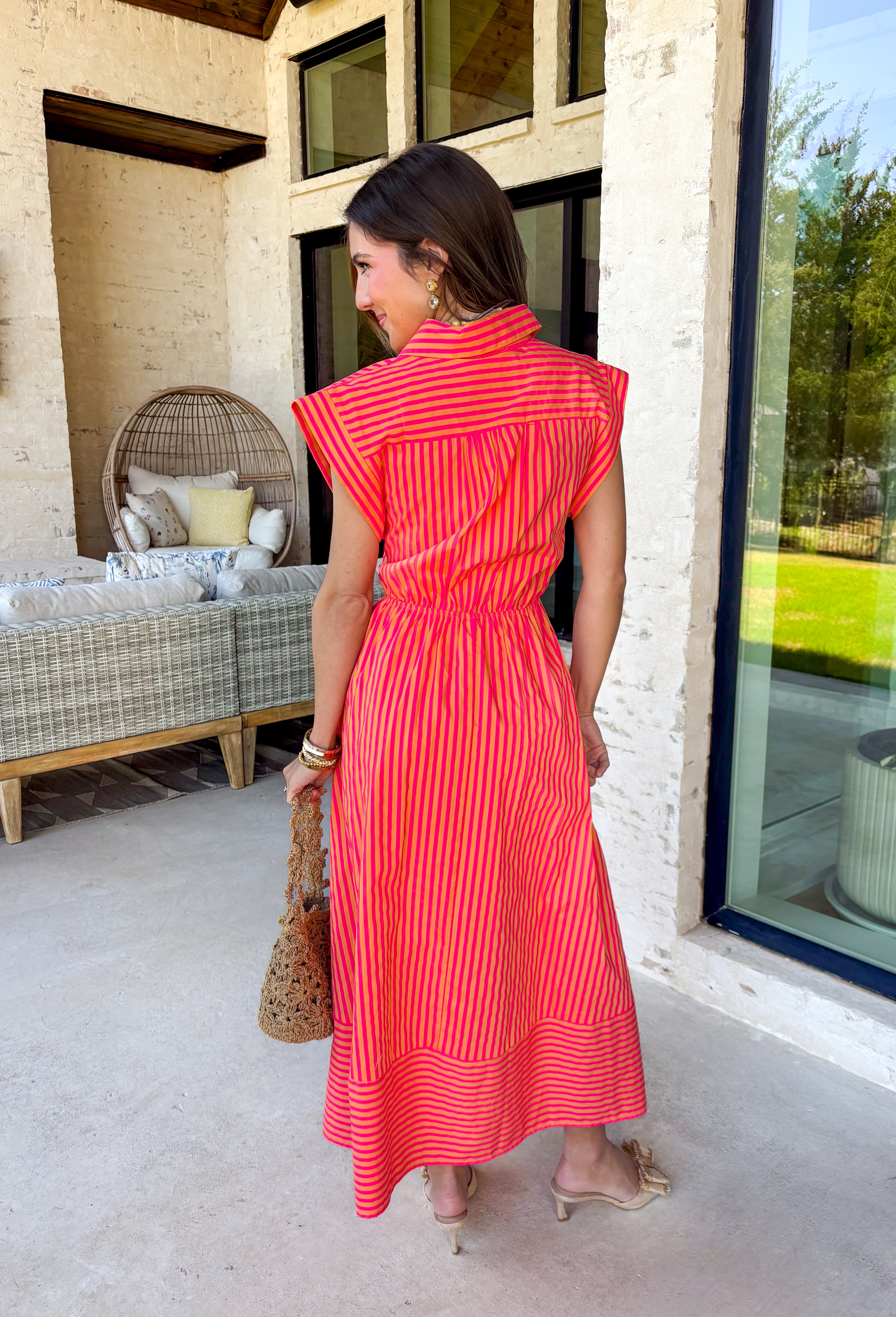 Bold, bright, and made for sunshine—this striped cap sleeve midi dress by Entro is a total spring-and-summer mood. With its vibrant orange and hot pink stripe combo, it’s the kind of dress that instantly makes you feel happy the second you put it on. The v-neckline is finished with a cute self-tie detail at the front, giving it a playful, flattering touch that feels extra special without being too much. 
