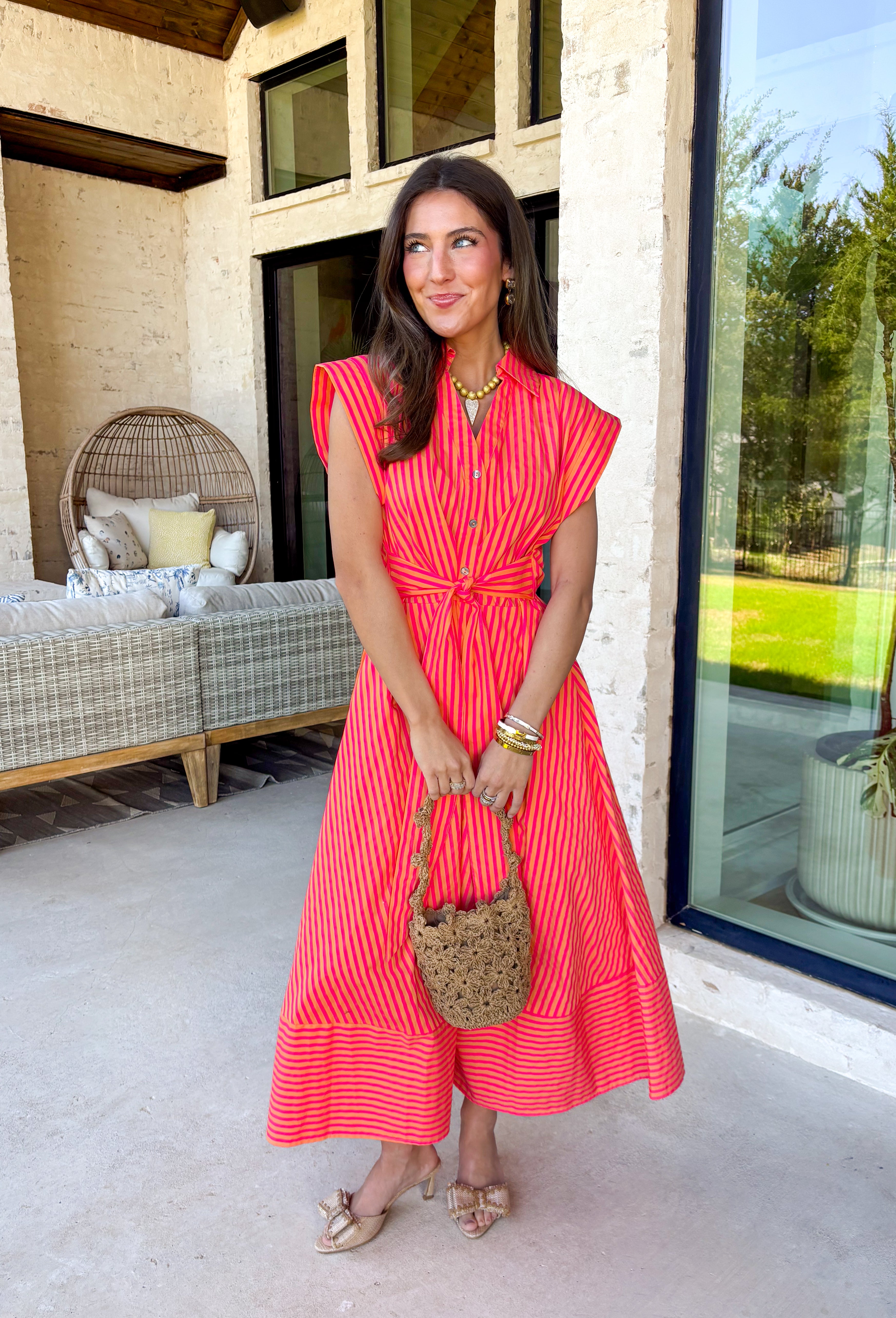 Bold, bright, and made for sunshine—this striped cap sleeve midi dress by Entro is a total spring-and-summer mood. With its vibrant orange and hot pink stripe combo, it’s the kind of dress that instantly makes you feel happy the second you put it on. The v-neckline is finished with a cute self-tie detail at the front, giving it a playful, flattering touch that feels extra special without being too much. 