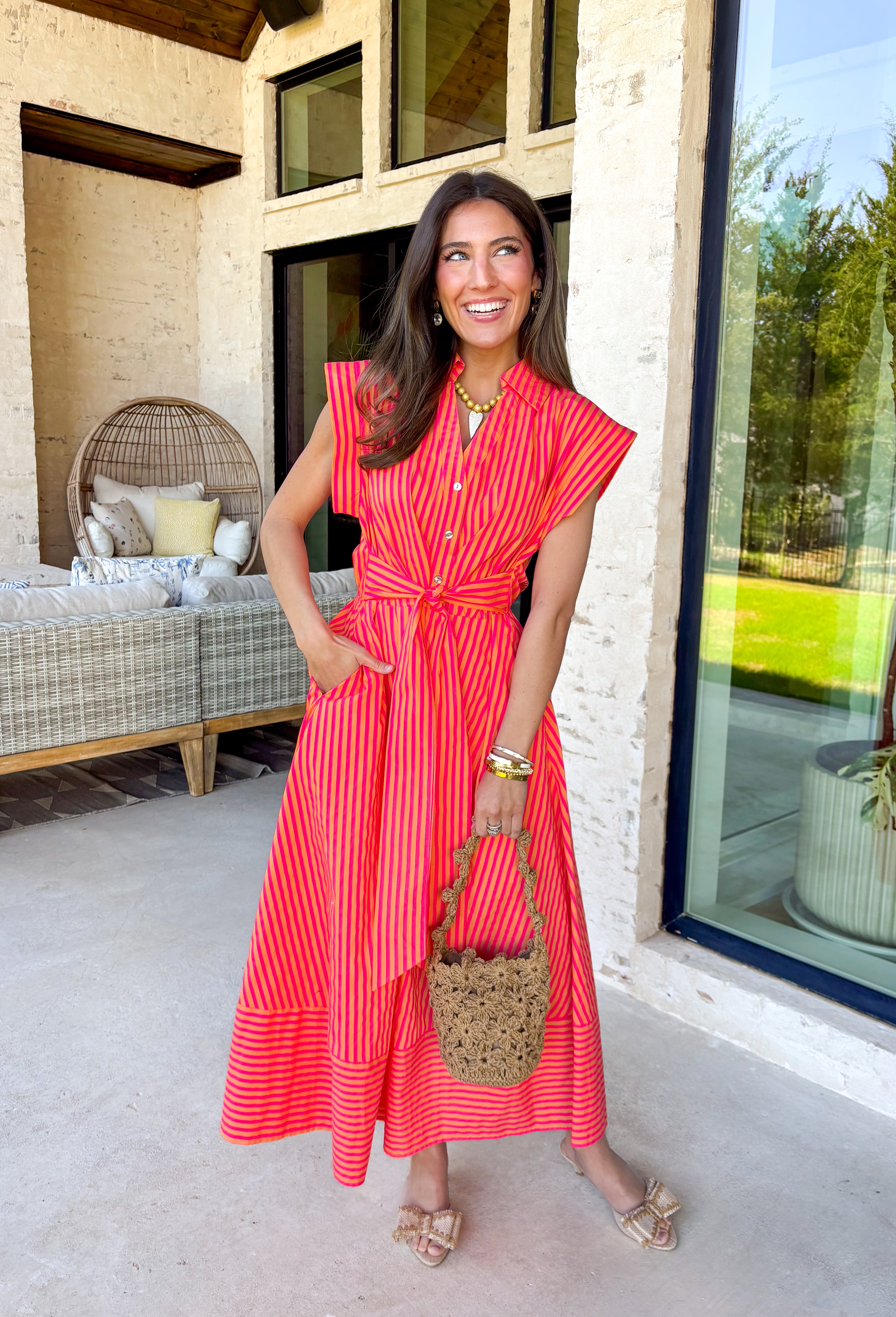Bold, bright, and made for sunshine—this striped cap sleeve midi dress by Entro is a total spring-and-summer mood. With its vibrant orange and hot pink stripe combo, it’s the kind of dress that instantly makes you feel happy the second you put it on. The v-neckline is finished with a cute self-tie detail at the front, giving it a playful, flattering touch that feels extra special without being too much. 