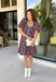 Bring timeless elegance to your fall wardrobe with this beautifully detailed dress from Entro. Designed with a rich brown backdrop and a stunning blue floral print, this feminine dress is full of eye-catching seasonal charm. The flattering square neckline is accented with beautiful blue contrast trim, while the pleated waist creates a flattering, defined silhouette. 