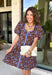 Bring timeless elegance to your fall wardrobe with this beautifully detailed dress from Entro. Designed with a rich brown backdrop and a stunning blue floral print, this feminine dress is full of eye-catching seasonal charm. The flattering square neckline is accented with beautiful blue contrast trim, while the pleated waist creates a flattering, defined silhouette. 