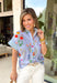 Bright, cheerful, and full of spring personality, this light blue button-down top by Entro is an instant outfit-lifter. Featuring a colorful floral print with pops of pink, green, red, and yellow, it brings a playful feel to a classic silhouette. The blue and white striped sleeves and neckline add a fun contrast, while the subtle ruffle neckline gives it a soft, feminine finish. Lightweight cotton makes it perfect for warm days and easy layering.