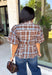 Classic plaid gets a fresh fall update with this brown and blue blouse from Entro. The mix of warm brown and cool blue creates an eye-catching color combination that fits right into your autumn wardrobe. A shirt collar and button-front closure give it a classic feel, while pleated detailing at the front and back adds shape and texture. The self-tie belt lets you define the waist, and the peplum hem creates a flattering finish that's perfect with denim or trousers. 