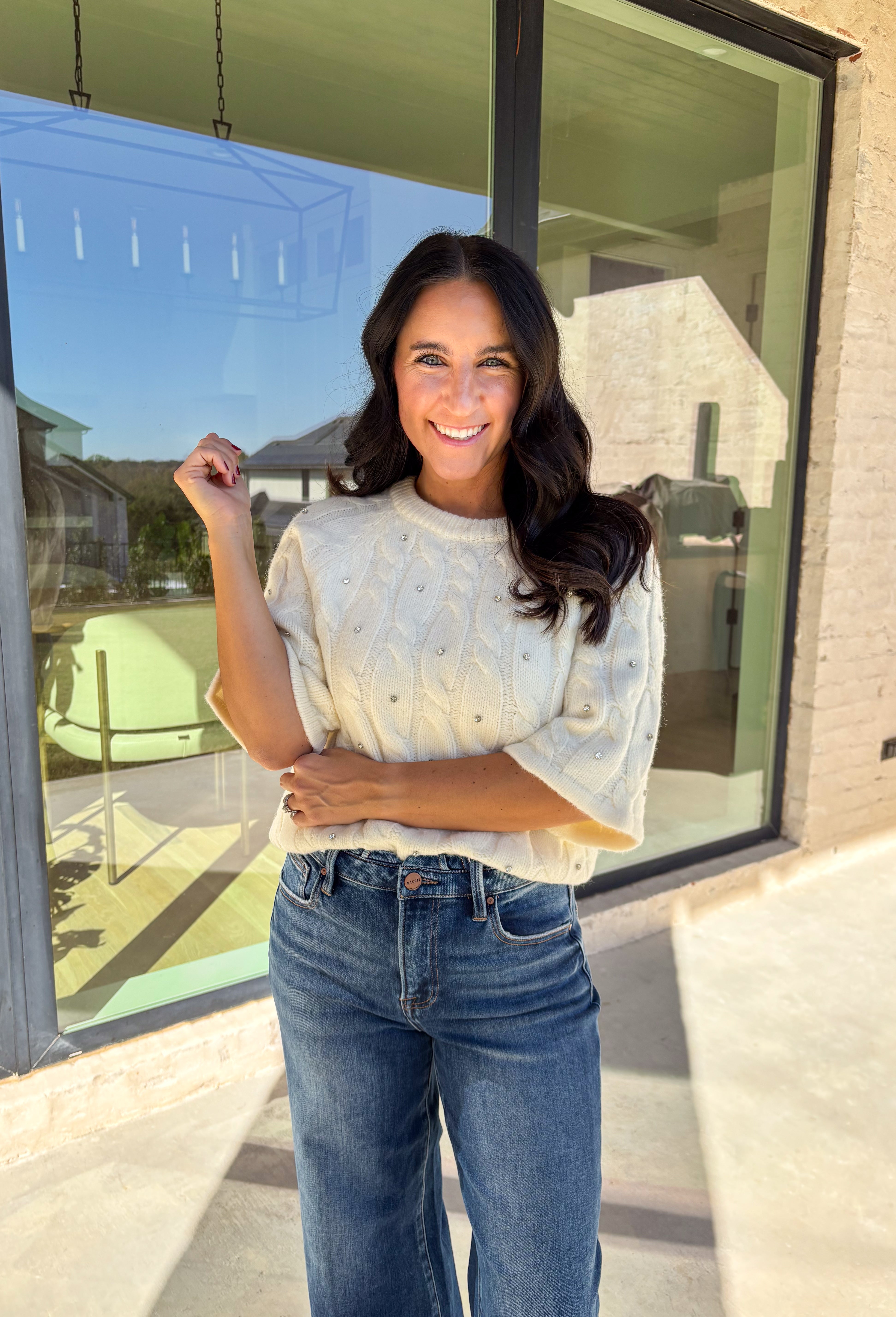 Add a little sparkle to your holiday style with this cream cable knit sweater by Entro. Featuring short sleeves and delicate crystal embellishments on the front, this cozy knit is the perfect mix of classic and festive. The soft texture and timeless cable design make it an easy choice for everything from office parties to family gatherings.