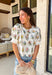 If you love a top that feels sweet, unique, and totally spring-ready, this off white top by Entro is going to be your new favorite. The patchwork-style floral embroidery along the front and sleeves is packed with beautiful color—brown, pink, green, yellow, and blue—giving it that one-of-a-kind look that instantly upgrades even your simplest denim. 