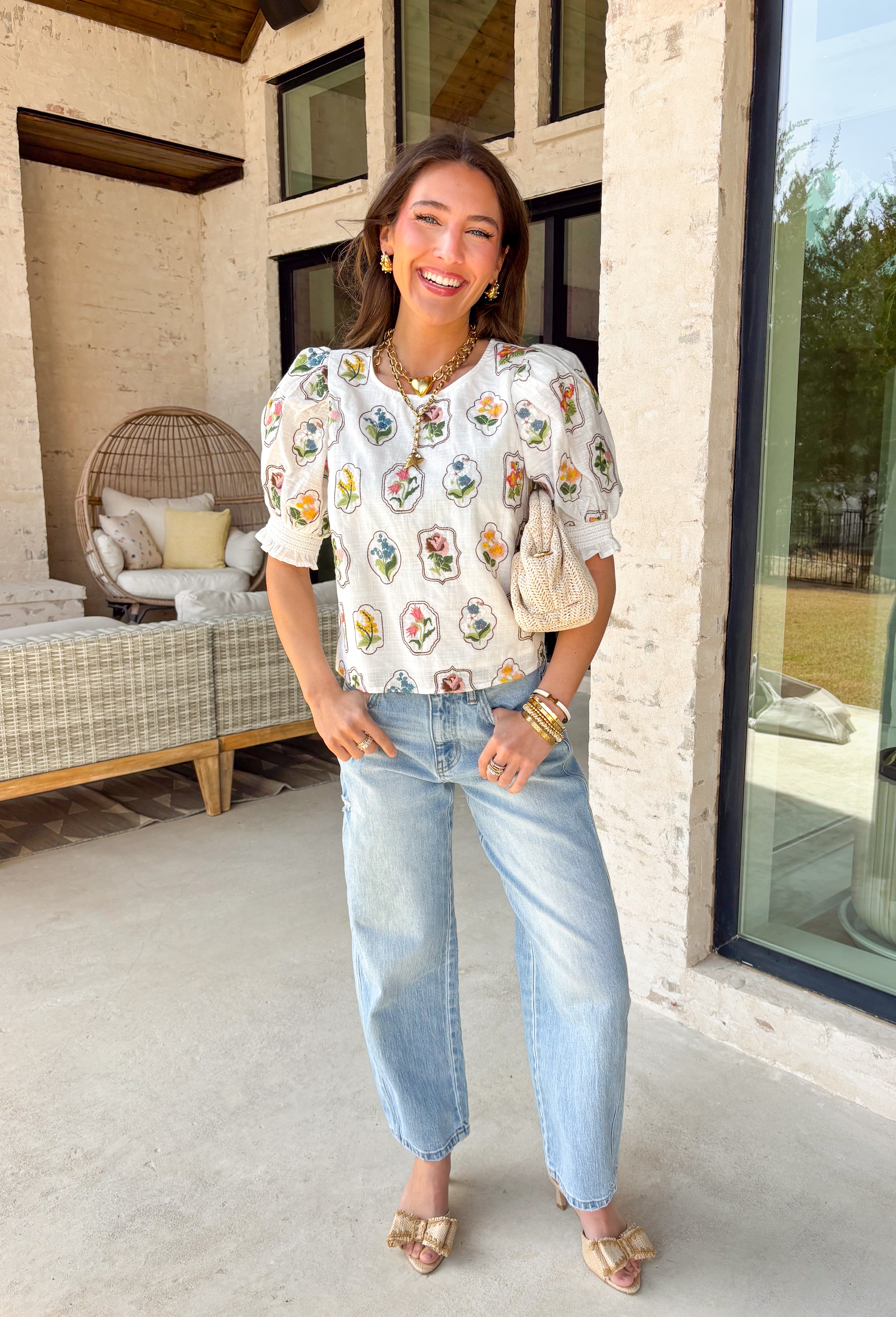 If you love a top that feels sweet, unique, and totally spring-ready, this off white top by Entro is going to be your new favorite. The patchwork-style floral embroidery along the front and sleeves is packed with beautiful color—brown, pink, green, yellow, and blue—giving it that one-of-a-kind look that instantly upgrades even your simplest denim. 