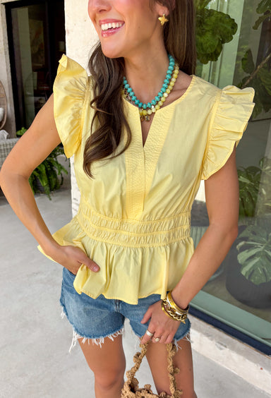 This pastel yellow top is pure sunshine in your summer wardrobe! The soft color feels fresh and cheerful, while the elastic waist creates a flattering, easy shape that’s comfortable for all-day wear. The ruffle sleeves add a feminine touch, and the v-neckline keeps it light and breezy for warm days. Made from breathable cotton, it’s perfect for everything from casual outings to lunch with friends. Pair it with white denim or shorts for an effortlessly bright look—this one is an instant mood booster.
