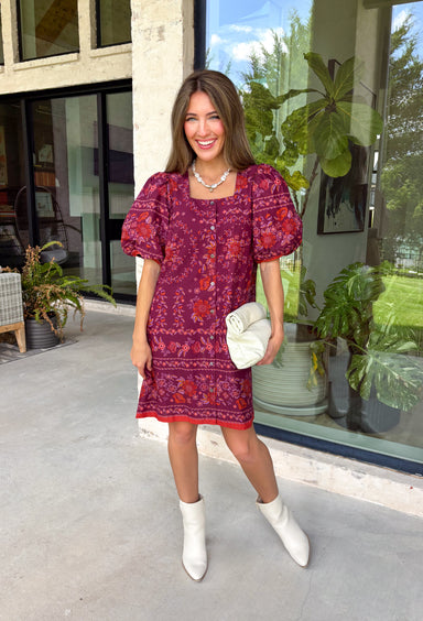 Rich fall colors and timeless details come together beautifully in this floral dress. Designed in a gorgeous burgundy hue with a vibrant orange and purple floral print, this dress captures everything we love about the season. The flattering square neckline and button-front detail create a polished, feminine silhouette, while the contrast trim adds an eye-catching finishing touch. Puff sleeves with elastic hems, side pockets, and a fully lined design make this dress as comfortable as it is charming.