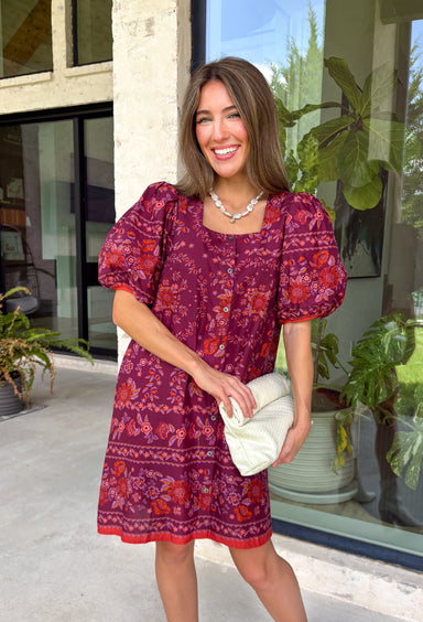 Rich fall colors and timeless details come together beautifully in this floral dress. Designed in a gorgeous burgundy hue with a vibrant orange and purple floral print, this dress captures everything we love about the season. The flattering square neckline and button-front detail create a polished, feminine silhouette, while the contrast trim adds an eye-catching finishing touch. Puff sleeves with elastic hems, side pockets, and a fully lined design make this dress as comfortable as it is charming.
