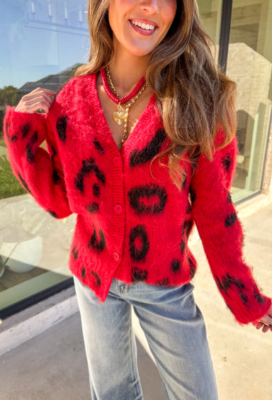 Make a bold statement while staying cozy in this red fuzzy button-down cardigan by See and Be Seen. Featuring a playful black leopard print, this cardigan adds a fun twist to chilly-day layering. The ultra-soft texture feels as good as it looks, making it a go-to for everything from lounging at home to dressing up your favorite denim.