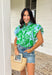 Soft, fresh, and full of spring charm! This light blue short sleeve top features a beautiful green floral print layered over textured floral eyelet lace for the prettiest dimension. It’s feminine without feeling fussy — just the right balance of sweet and polished. Designed with a classic button down front, this top is finished with a ruffle neckline and ruffle sleeves that add movement and a soft romantic touch. Crafted from breathable 100% cotton.