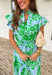 Soft, feminine, and full of spring charm! This light blue midi dress features delicate eyelet lace detailing throughout paired with a fresh green floral print for the prettiest layered texture. The subtle ruffle neckline adds a romantic touch, while the gold button details down the front bring a hint of shine. Designed with a matching self-tie closure to gently define the waist and a flowy tiered skirt for beautiful movement, this dress feels both polished and easy to wear. 