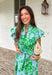 Soft, feminine, and full of spring charm! This light blue midi dress features delicate eyelet lace detailing throughout paired with a fresh green floral print for the prettiest layered texture. The subtle ruffle neckline adds a romantic touch, while the gold button details down the front bring a hint of shine. Designed with a matching self-tie closure to gently define the waist and a flowy tiered skirt for beautiful movement, this dress feels both polished and easy to wear. 