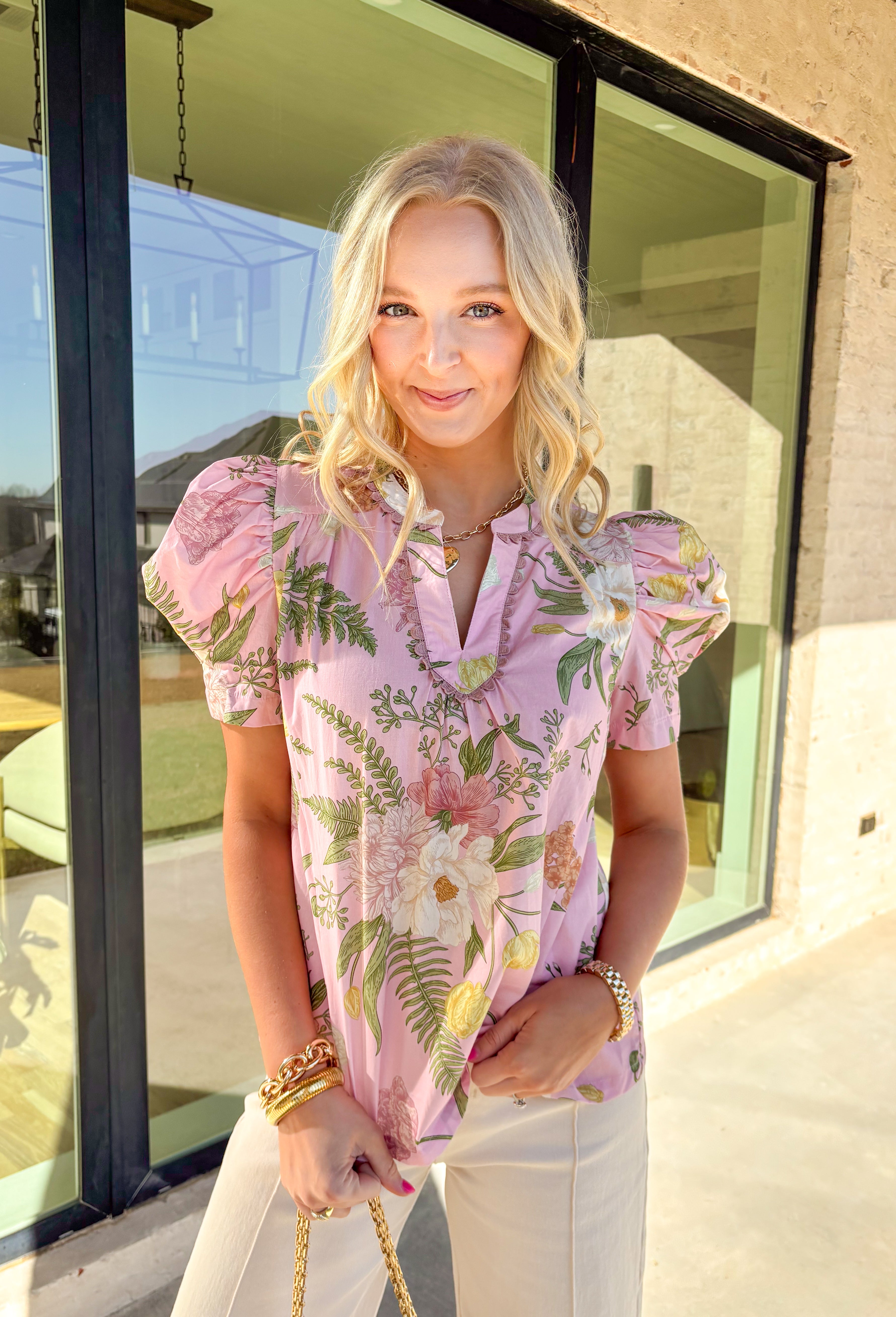 Sweet, soft, and ready for sunshine, this light pink floral top by Umgee is a spring staple you’ll reach for again and again. Featuring a delicate floral print in shades of green, pink, cream, and tan, this top feels fresh and feminine without trying too hard. The puff sleeves add just the right amount of volume, while the scalloped trim along the front gives it a charming, elevated finish that’s perfect for everyday wear.