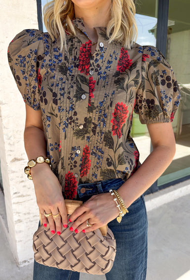Bring warm autumn colors to your everyday wardrobe with this effortlessly feminine floral blouse. Designed with a beautiful camel backdrop and a vibrant floral print in shades of red, black, olive, and navy, this timeless top is perfect for everything from workdays to weekend outings. Delicate pleating along the front adds beautiful texture, while the button-front design and elastic cuff sleeves create a polished yet comfortable look. 