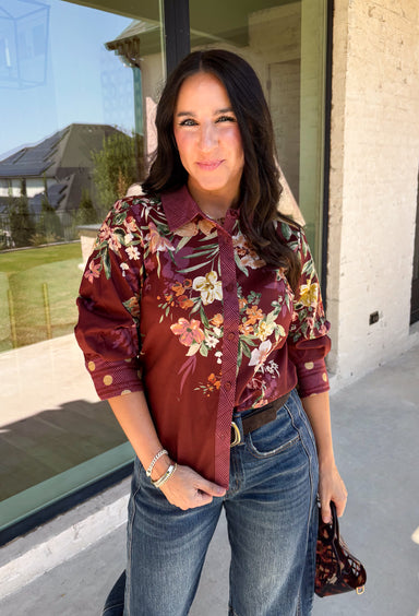 Bring a little fall color into your workweek with this burgundy floral blouse from Current Air. The rich burgundy background is covered in a seasonal floral print, while contrasting stripe trim throughout gives the design a fresh, eye-catching finish. A collared neckline and button-down front keep the look classic and work-ready, with ¾ length sleeves making it an easy choice for transitioning into cooler days. 