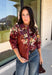Bring a little fall color into your workweek with this burgundy floral blouse from Current Air. The rich burgundy background is covered in a seasonal floral print, while contrasting stripe trim throughout gives the design a fresh, eye-catching finish. A collared neckline and button-down front keep the look classic and work-ready, with ¾ length sleeves making it an easy choice for transitioning into cooler days. 