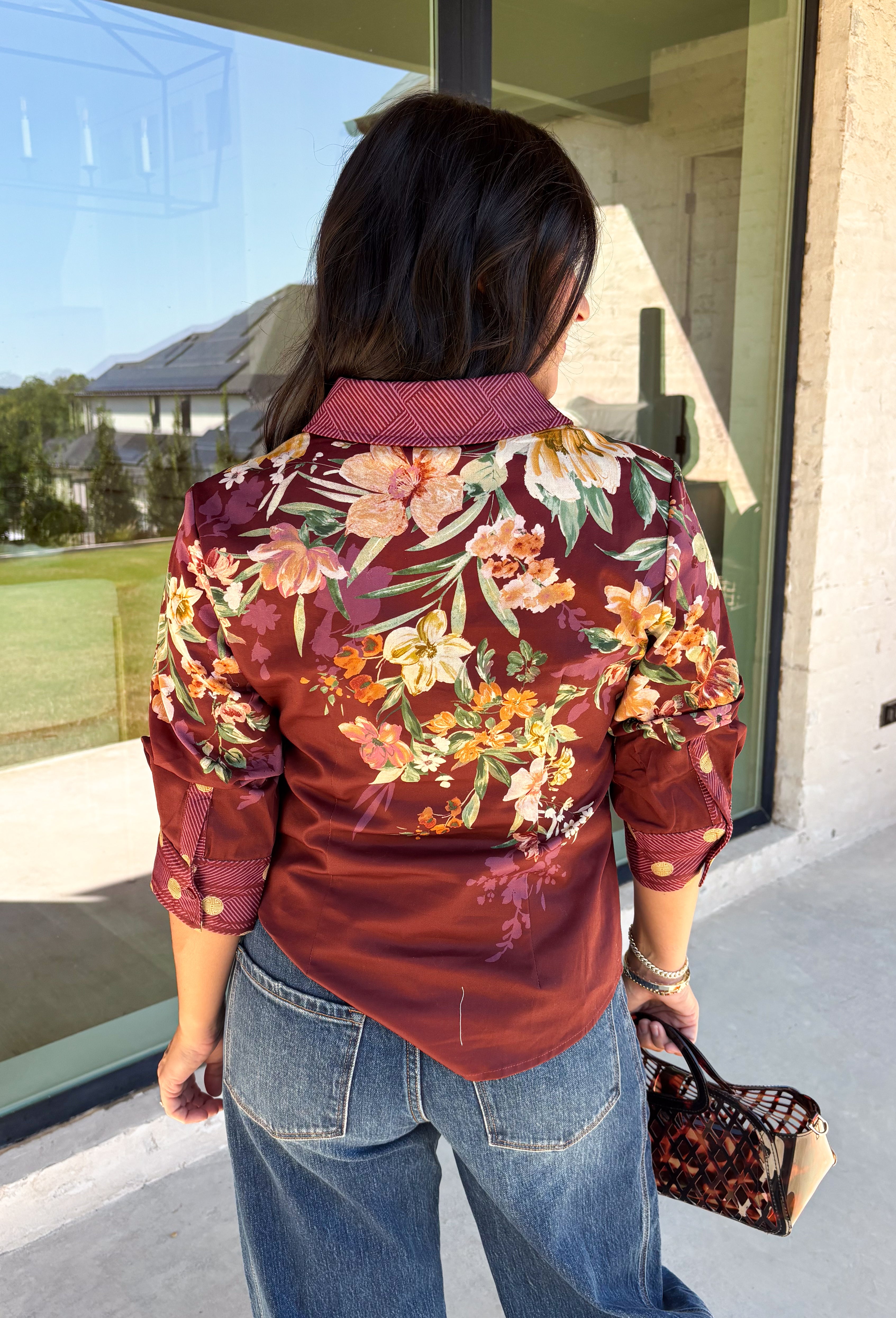 Bring a little fall color into your workweek with this burgundy floral blouse from Current Air. The rich burgundy background is covered in a seasonal floral print, while contrasting stripe trim throughout gives the design a fresh, eye-catching finish. A collared neckline and button-down front keep the look classic and work-ready, with ¾ length sleeves making it an easy choice for transitioning into cooler days. 