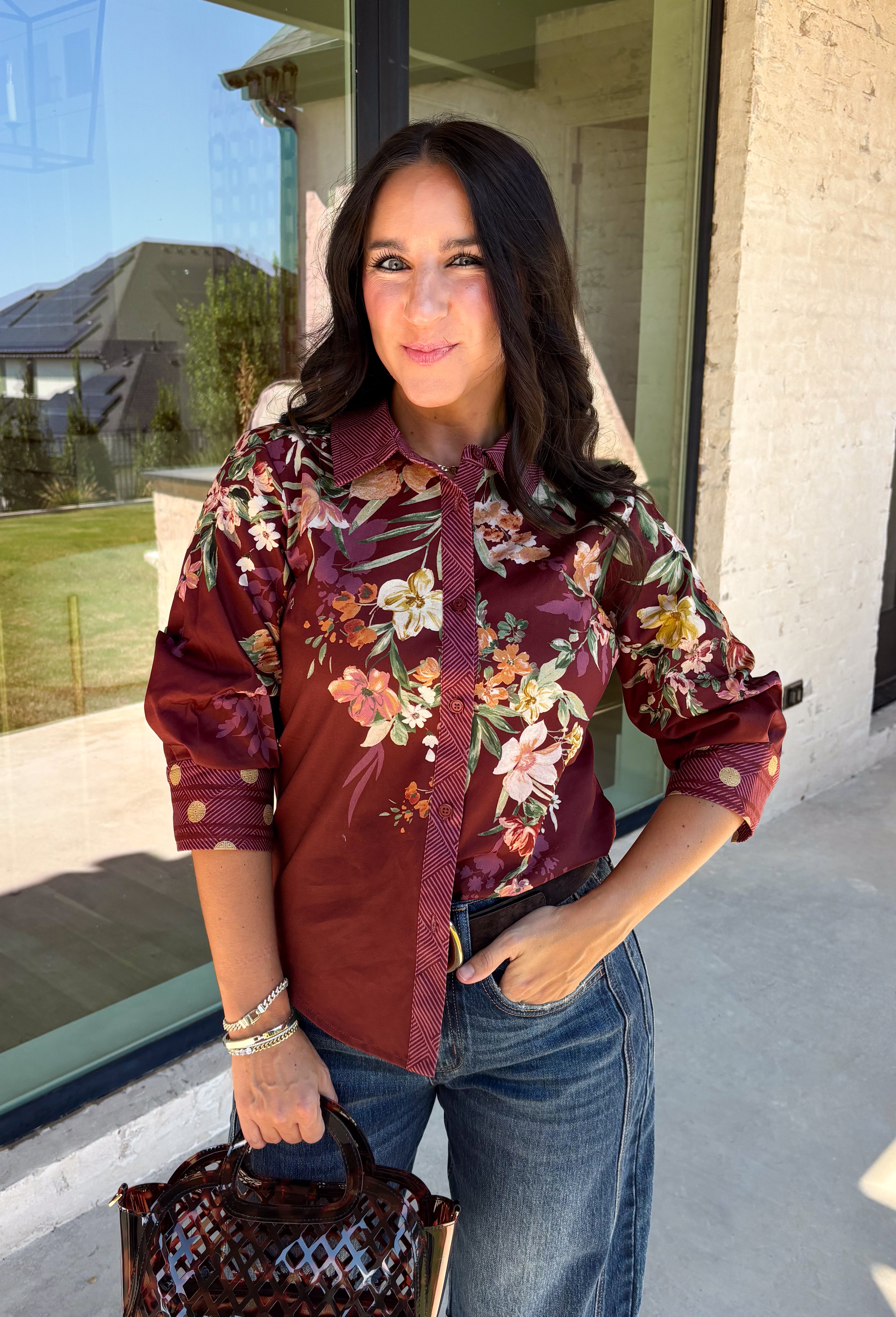 Bring a little fall color into your workweek with this burgundy floral blouse from Current Air. The rich burgundy background is covered in a seasonal floral print, while contrasting stripe trim throughout gives the design a fresh, eye-catching finish. A collared neckline and button-down front keep the look classic and work-ready, with ¾ length sleeves making it an easy choice for transitioning into cooler days. 