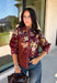 Bring a little fall color into your workweek with this burgundy floral blouse from Current Air. The rich burgundy background is covered in a seasonal floral print, while contrasting stripe trim throughout gives the design a fresh, eye-catching finish. A collared neckline and button-down front keep the look classic and work-ready, with ¾ length sleeves making it an easy choice for transitioning into cooler days. 