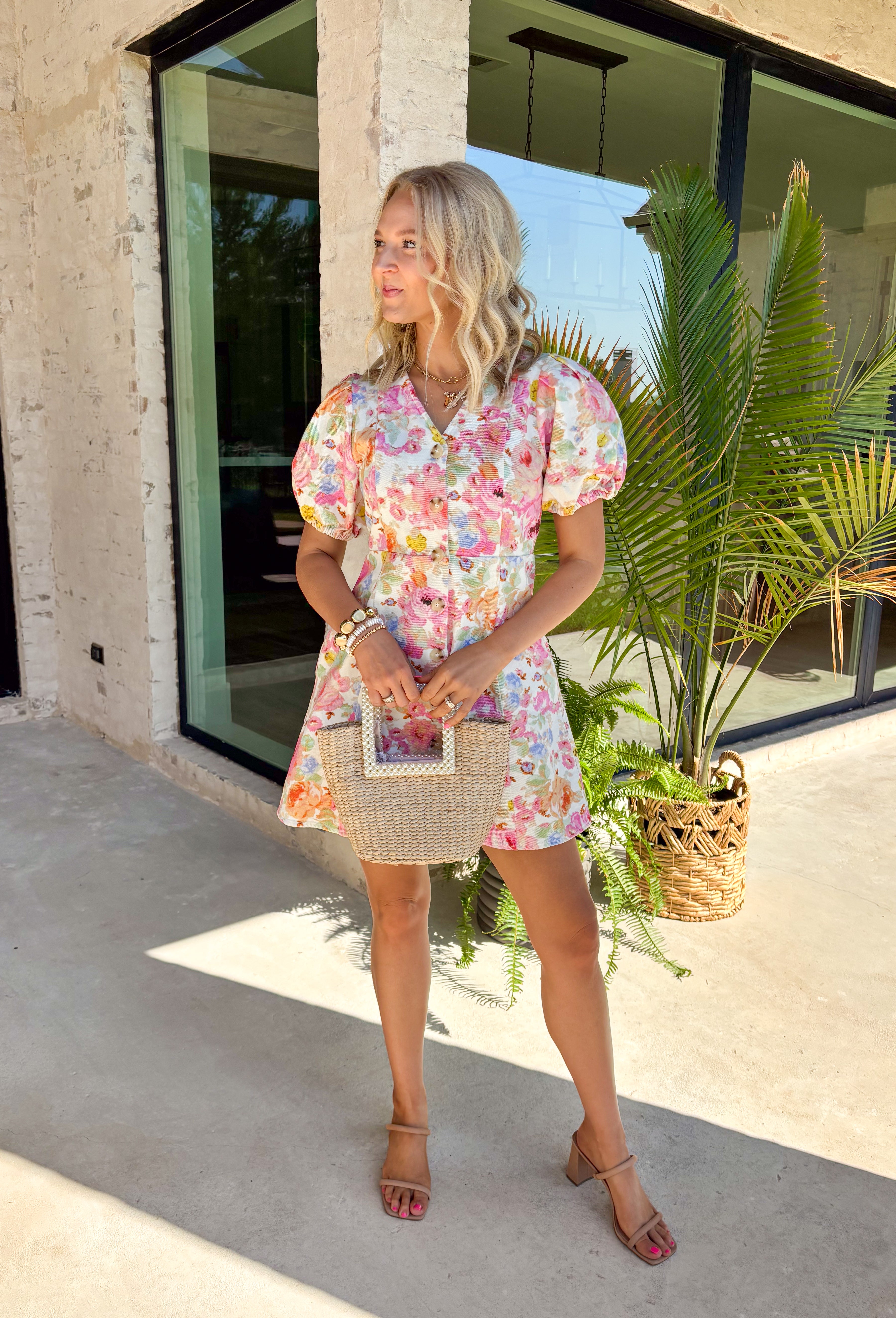 This floral puff sleeve dress is the kind of piece that makes summer styling feel so easy! Designed with a soft neutral base and pops of pink, green, orange, and periwinkle, it brings just the right amount of color while still feeling wearable for everyday plans. The flattering v-neckline and button front add a classic touch, while the puff sleeves and elastic openings give it that feminine shape everyone loves. And yes—side pockets make it even better.  