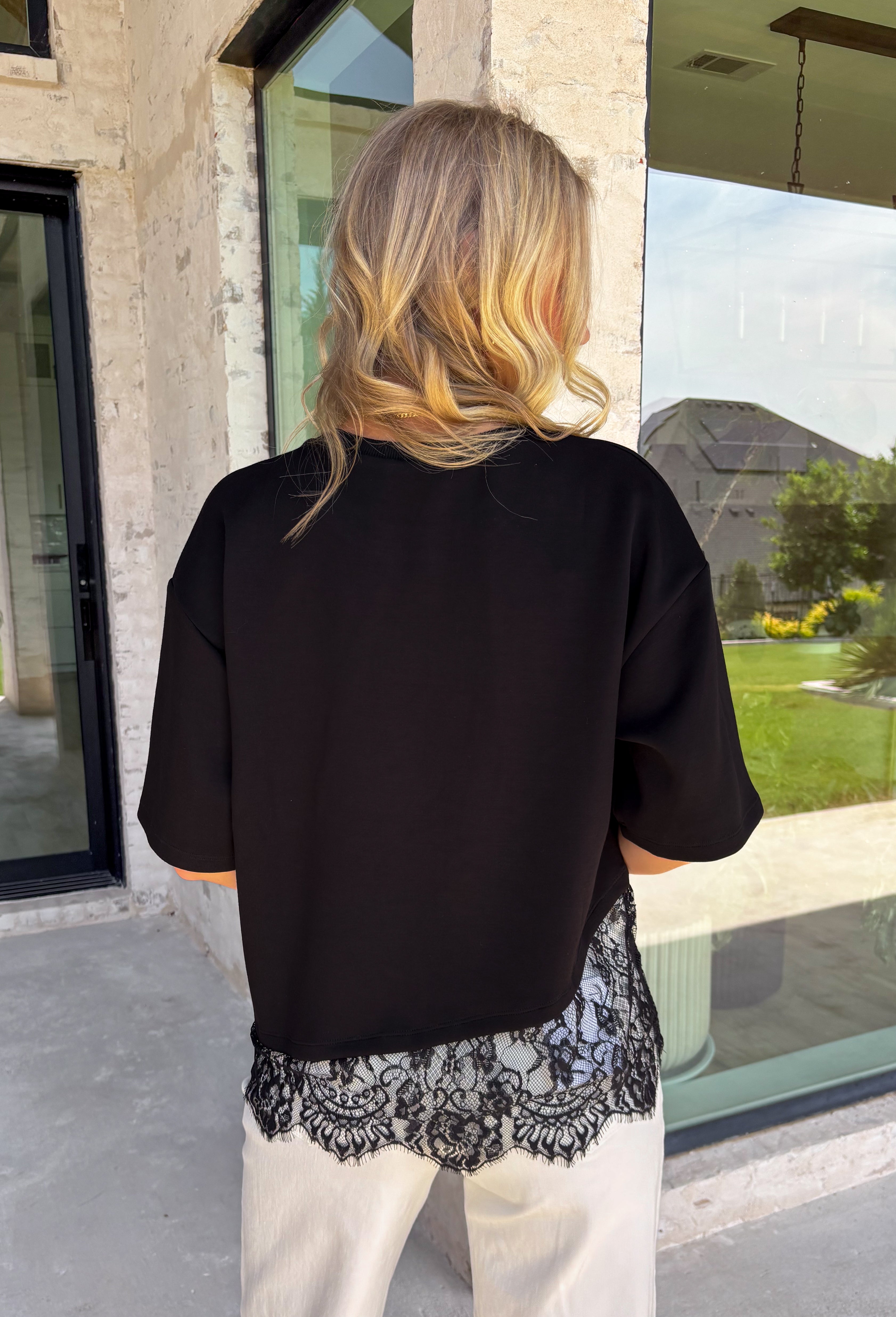 Elevate your everyday fall wardrobe with this effortlessly chic knit top! Crafted from a soft, comfortable knit, this versatile piece is finished with a beautiful scalloped lace hem that adds just the right amount of feminine detail. The classic black color makes it easy to style with everything from denim to printed bottoms, while the trendy silhouette transitions seamlessly from the office to dinner plans. 