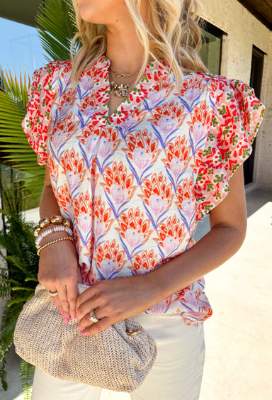 This abstract floral top is bringing all the bold, colorful energy your summer wardrobe needs! With a neutral base and vibrant pops of pink, coral, purple, red, white, and green, it’s the perfect statement piece that still feels easy to style. The contrasting floral print on the sleeves and neckline adds a fun, unexpected twist, while the ruffle sleeves and v-neckline keep it feminine and flattering. Lightweight and breathable, it’s perfect for warm days when you want to stand out without trying too hard. 