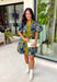 Bring timeless charm to your fall wardrobe with this beautifully detailed floral dress. Designed in a rich olive green with a stunning blue and navy floral print, this cotton dress is the perfect blend of classic and feminine. The flattering v-neckline, button-front design, and self-tie waist create a silhouette that's effortlessly polished, while the gathered back yoke adds a soft, flowy fit you'll love.