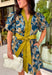 Bring timeless charm to your fall wardrobe with this beautifully detailed floral dress. Designed in a rich olive green with a stunning blue and navy floral print, this cotton dress is the perfect blend of classic and feminine. The flattering v-neckline, button-front design, and self-tie waist create a silhouette that's effortlessly polished, while the gathered back yoke adds a soft, flowy fit you'll love.