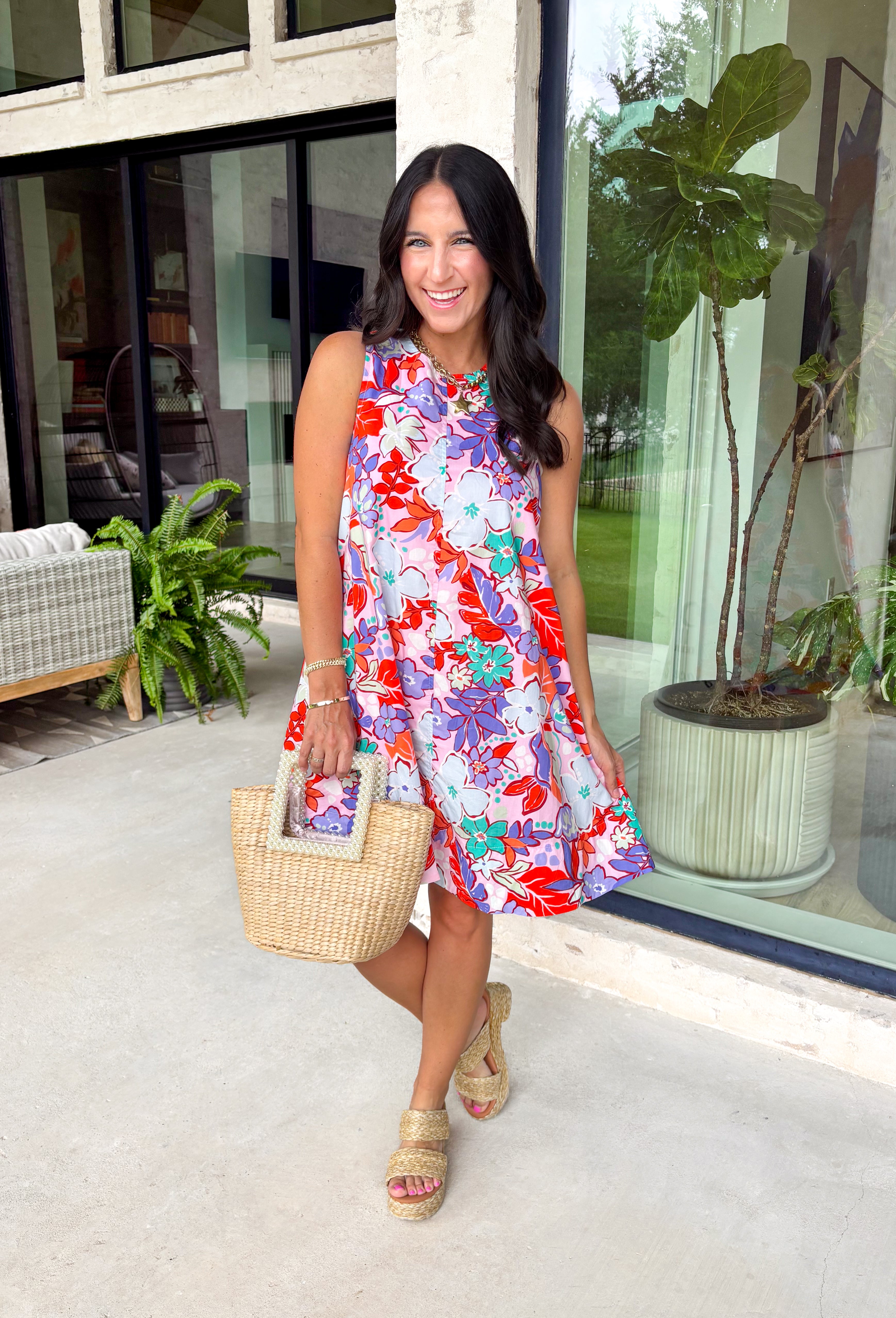 This pink floral midi dress is made for standing out in the best way this summer! Featuring a bold mix of tomato red, blue, green, purple, and white, it’s bright, fun, and full of personality. The sleeveless design keeps it cool and easy, while the tie detail at the back adds a subtle, feminine touch. Fully lined with side pockets (always a win), it’s as practical as it is eye-catching. Perfect for everything from brunch to vacation dinners, this is the kind of dress that does all the work for you. 