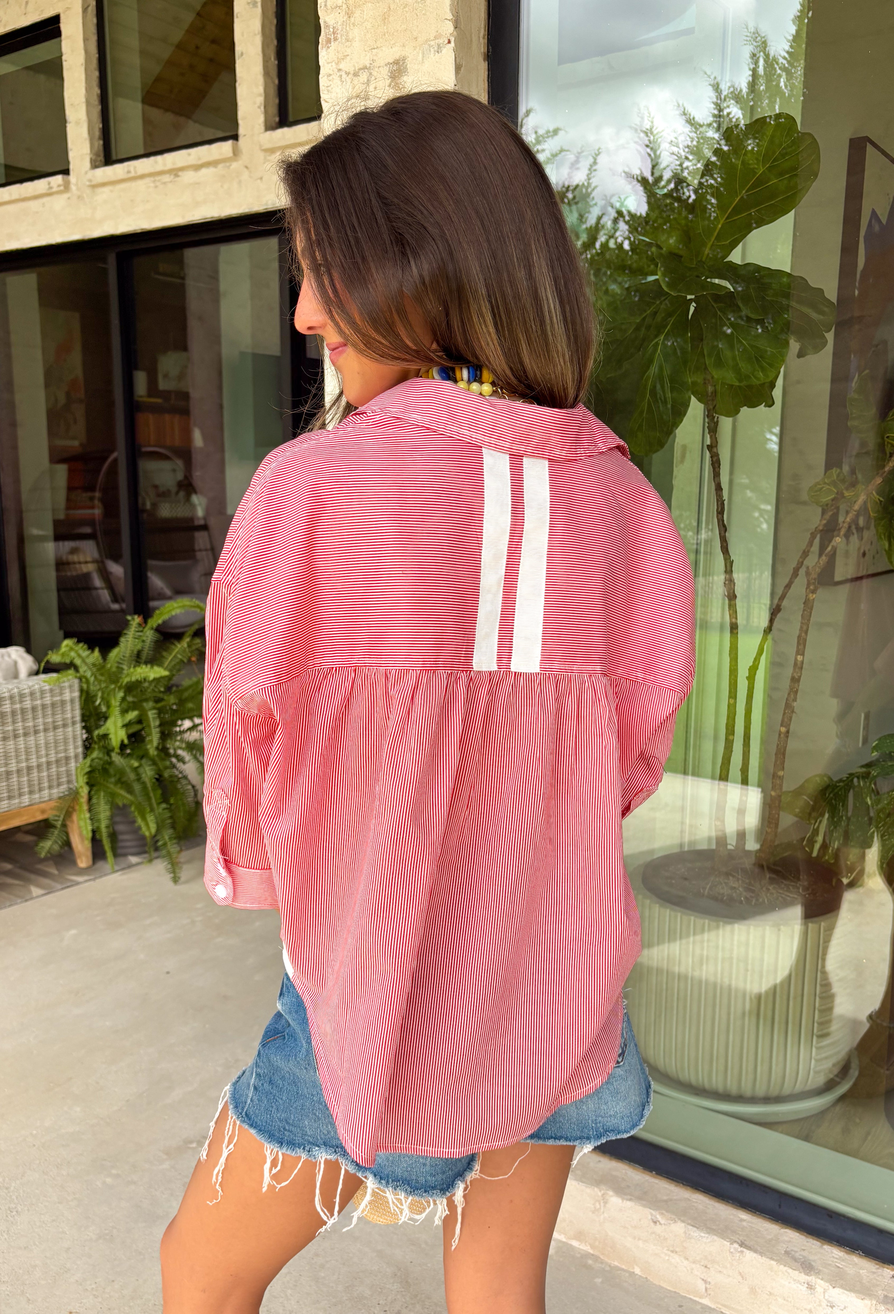 This red and white stripe button down top is a summer classic with a patriotic twist! The timeless stripe print makes it easy to style, while the white stripe detail along the back adds an unexpected touch that sets it apart. Designed with a collared neckline, front pocket, and easy button down silhouette, it’s the perfect piece for everything from backyard BBQs to fireworks and holiday weekends. Made from breathable cotton, it’s lightweight, comfortable, and ready for all your summer plans. 