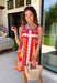 Bring on the sunshine in this vibrant floral dress! Designed with a neutral backdrop and a bold abstract floral print in shades of red, orange, pink, with pops of green and black, this dress is made to stand out all summer long. The pink rickrack trim along the front and hem adds a playful, vintage-inspired touch, while the adjustable straps and elastic back create a comfortable, flattering fit. 