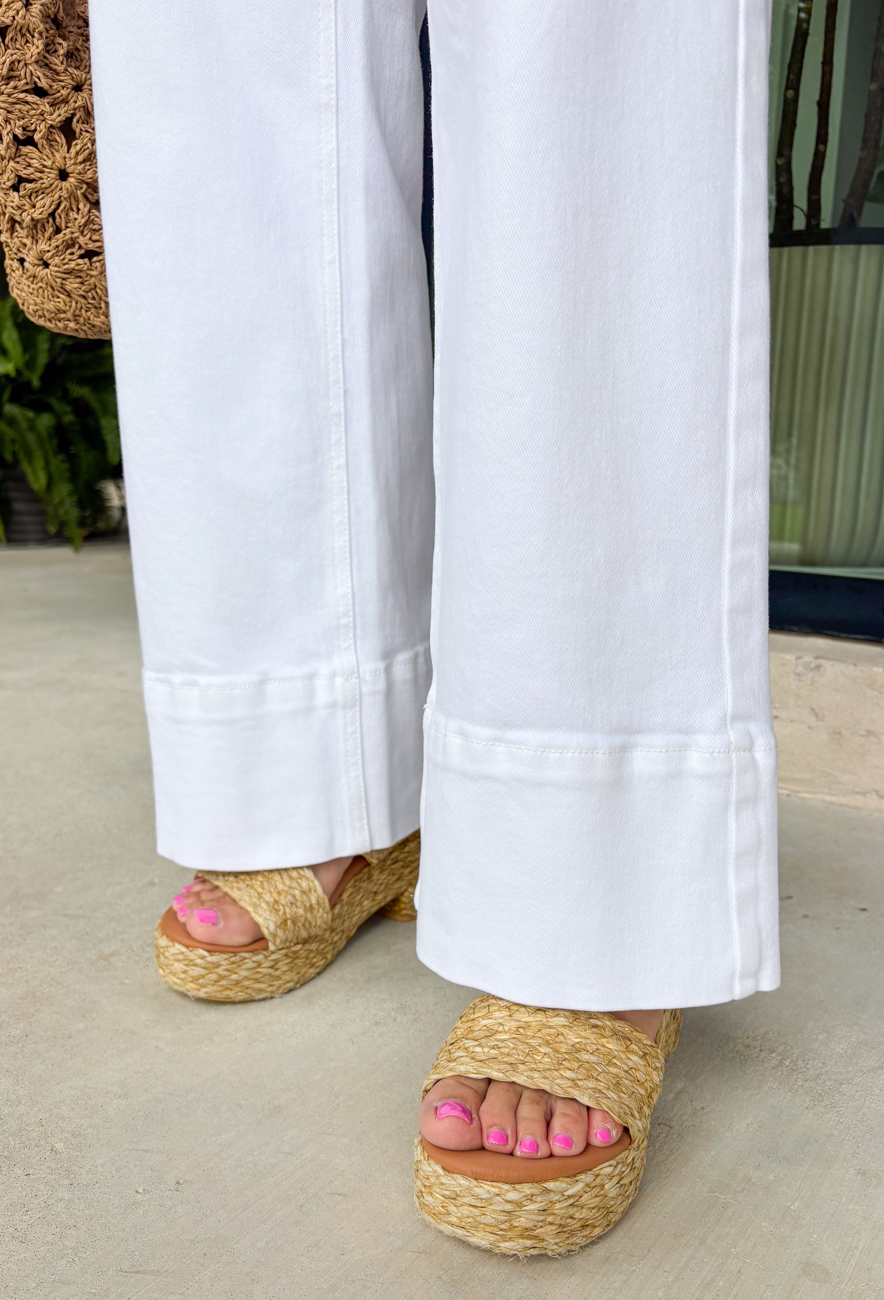 These white wide leg jeans are the ultimate summer staple with a flattering twist! Designed with built-in tummy control, they give you that smooth, confident fit while still feeling comfortable all day long. The classic wide leg silhouette with a clean, wide hem keeps the look timeless and easy to style for any occasion. With just the right amount of stretch, they move with you while holding their shape. 