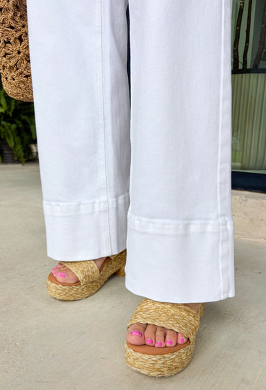 These white wide leg jeans are the ultimate summer staple with a flattering twist! Designed with built-in tummy control, they give you that smooth, confident fit while still feeling comfortable all day long. The classic wide leg silhouette with a clean, wide hem keeps the look timeless and easy to style for any occasion. With just the right amount of stretch, they move with you while holding their shape. 