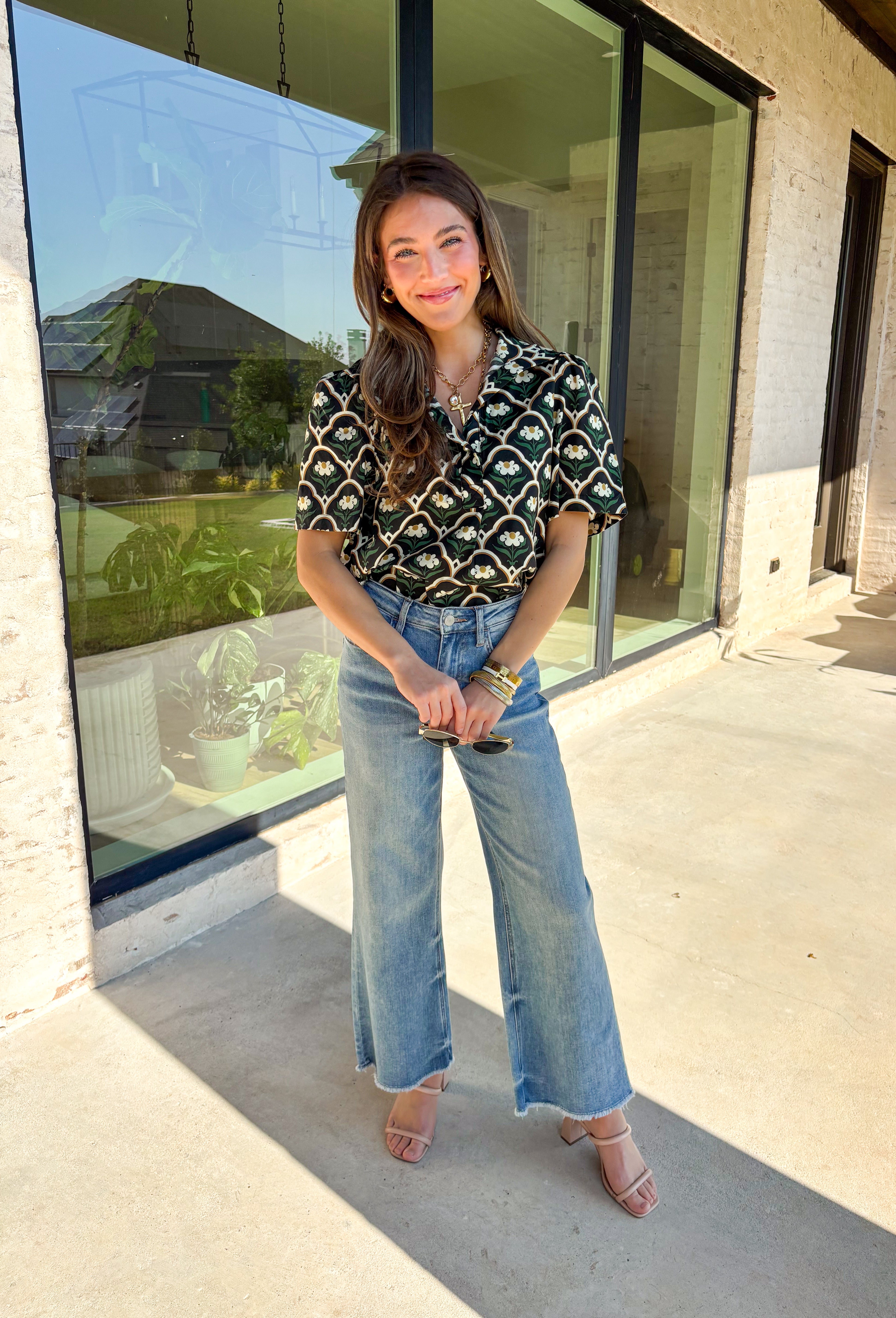 Polished with a hint of romance, this black puff shoulder top is the perfect way to bring fall florals into your wardrobe. The seasonal print in rich, neutral tones pairs beautifully with the structured puff sleeves and high neckline, while a pearl-accent single button closure at the front adds an elegant finishing touch. Crafted with a soft cotton blend and just the right amount of stretch, it’s comfortable enough for all-day wear yet dressy enough for special occasions.