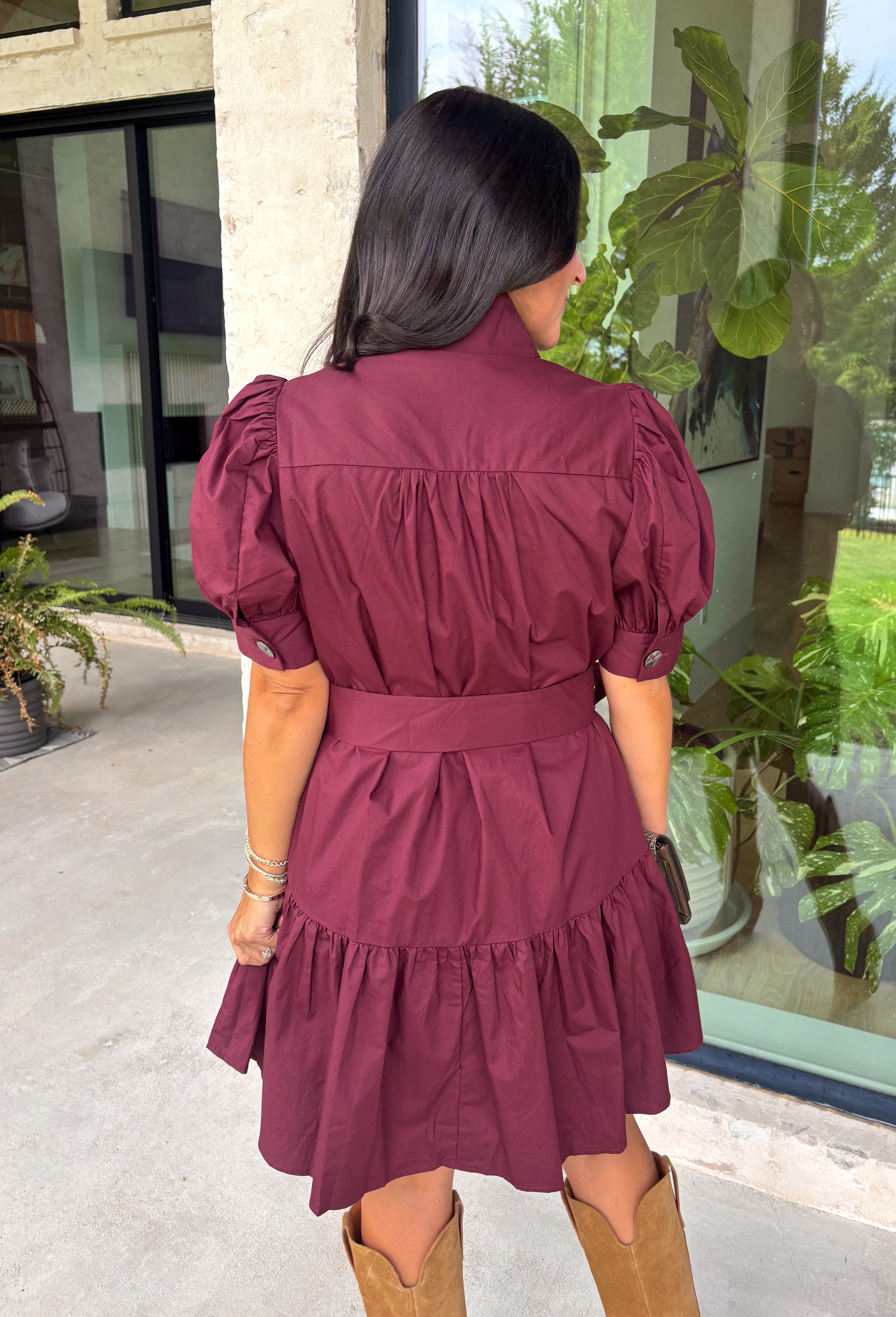 Rich in color and timeless in style, this burgundy dress is the perfect piece to carry you through the fall season. Designed with a classic button-front silhouette, this effortlessly feminine dress features charming puff sleeves and a matching self-tie belt that cinches the waist for a flattering, customizable fit. Side pockets add everyday functionality, while the fully lined cotton fabric keeps you comfortable from morning to night. 